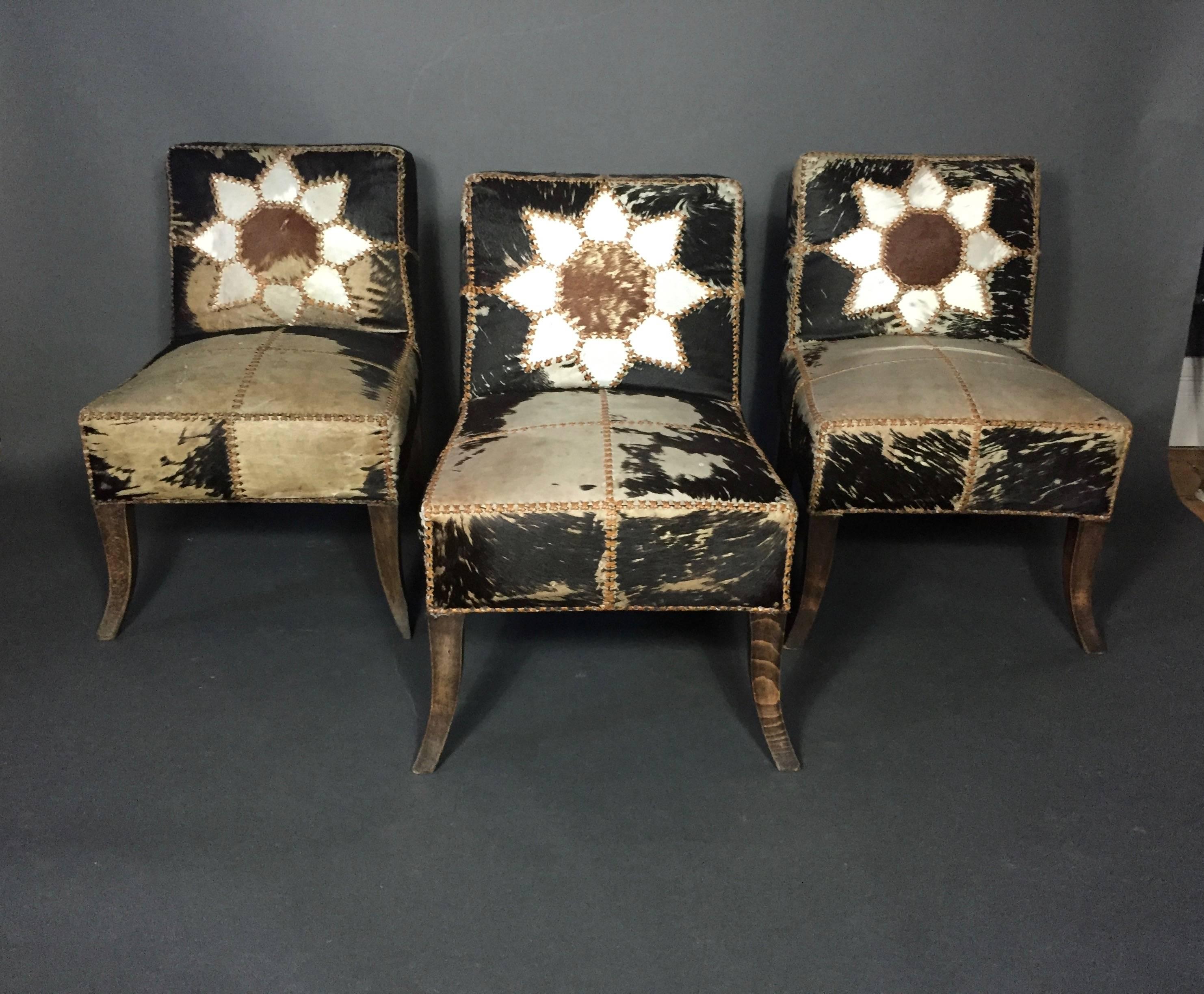 Nothing short of spectacular set of six dining chairs from the Art Deco period with eight-point floral patchwork design to front and back, leather strap binding and all original horse-hide covers. Metal Arab tag to each chair "Aliä