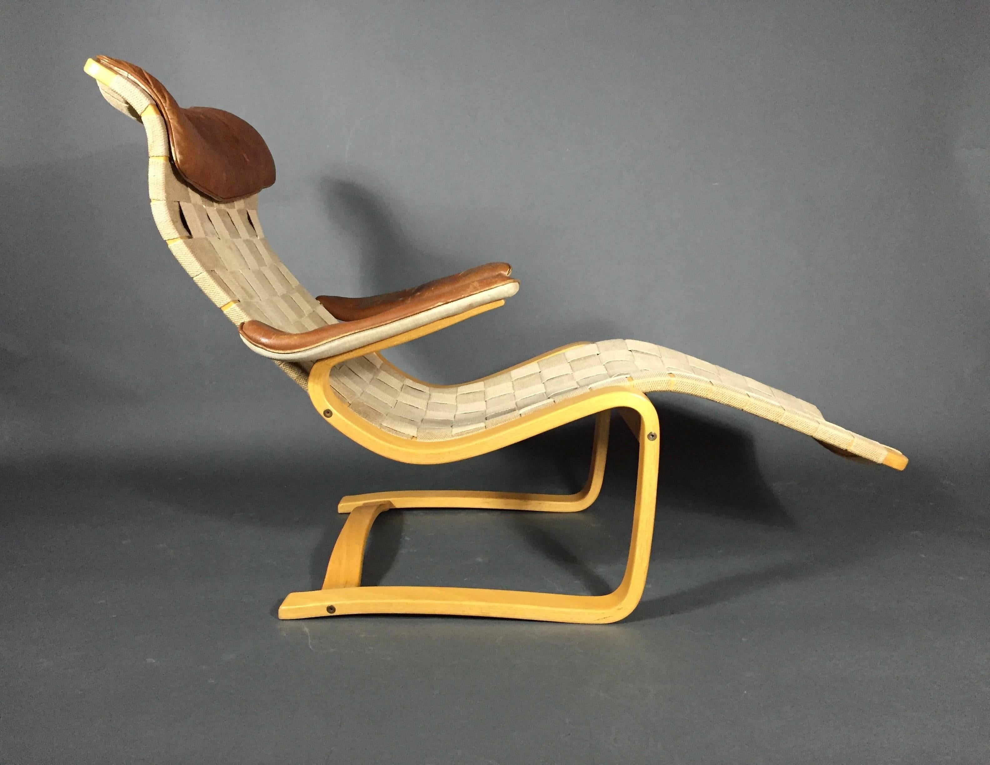 A rare sculpted lounge chair in laminated birch bentwood with original cotton webbing and leather to arms and back pillow - by Swedish Modern pioneer Gustaf Axel Berg (who worked with Arne Jacobsen on the early egg chair design). 1949. Stamped at