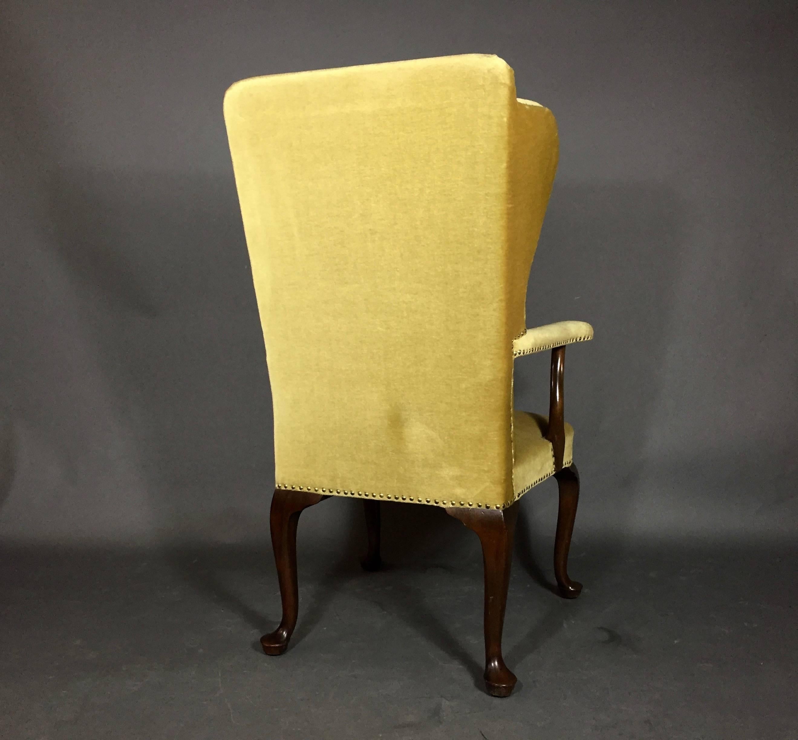 Wingback chair with stained beech frame, upholstered in seat, back, armrests with light gold mohair and studded with brass nails. Ascribed to Frits Henningsen, early 1940s, Denmark.