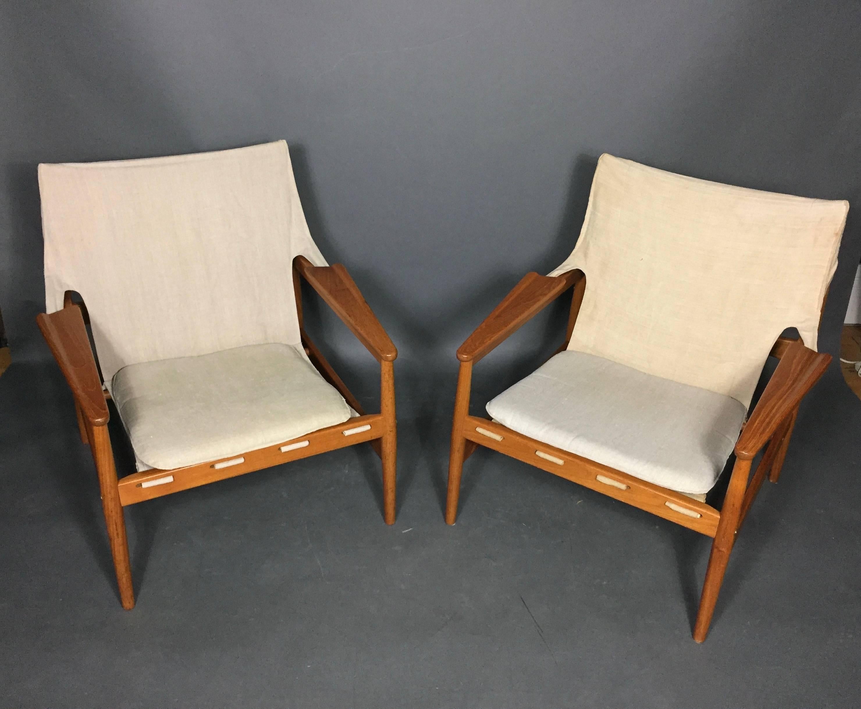 A very cool pair of sling chairs with canvas draped from top to chair seat front and supported with three buckled straps. Loose seat cushion. Designed by Hans Olsen (attributed) following a design originally completed for Viska Mobler, Sweden,