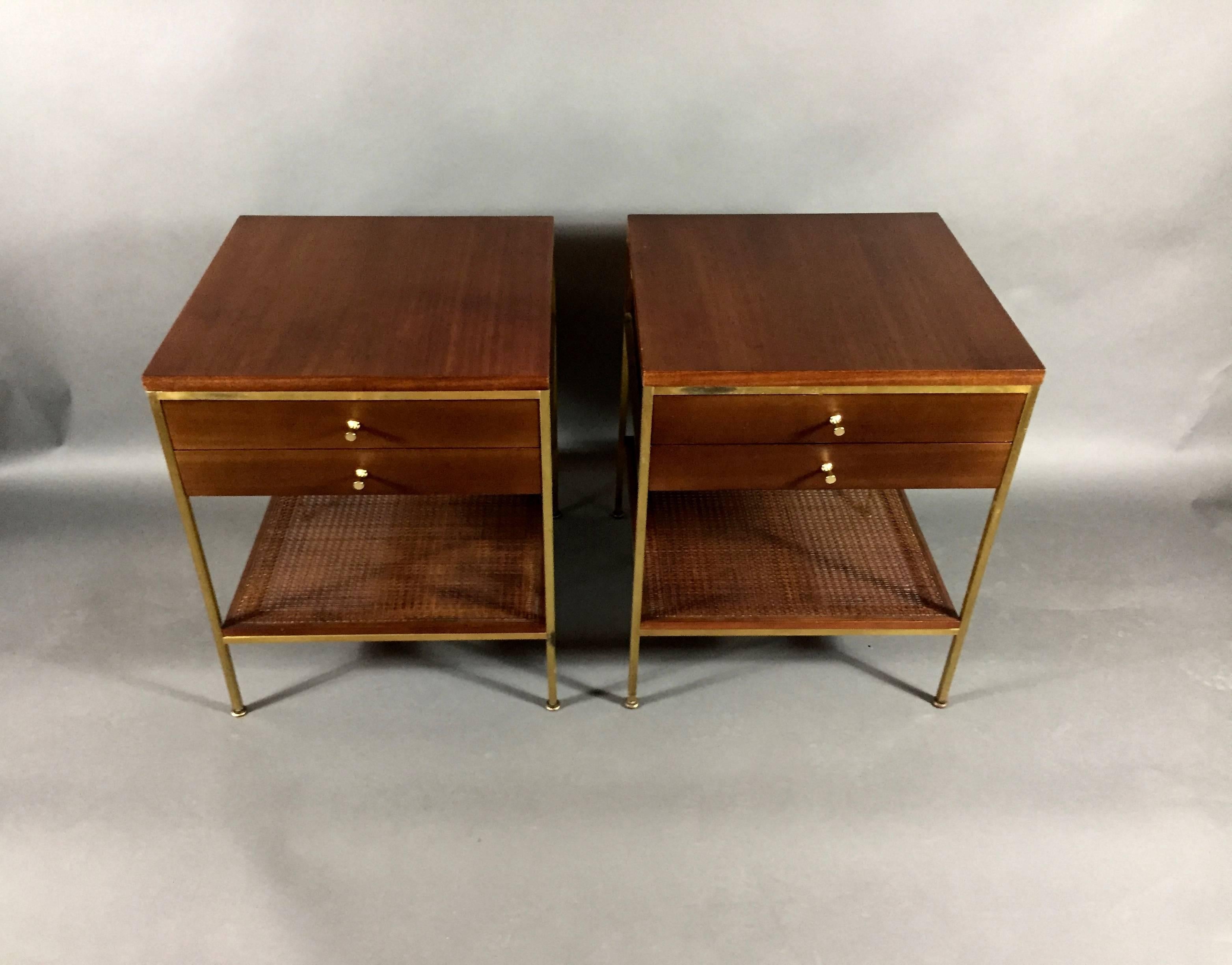 One of my favorite Paul McCobb designs - this pair of walnut nightstands or end tables is made with his iconic brass frame, two front drawers and lower cane shelf. Marked Calvin Grand Rapids - The Irvin Collection. Newly refinished walnut, brass in