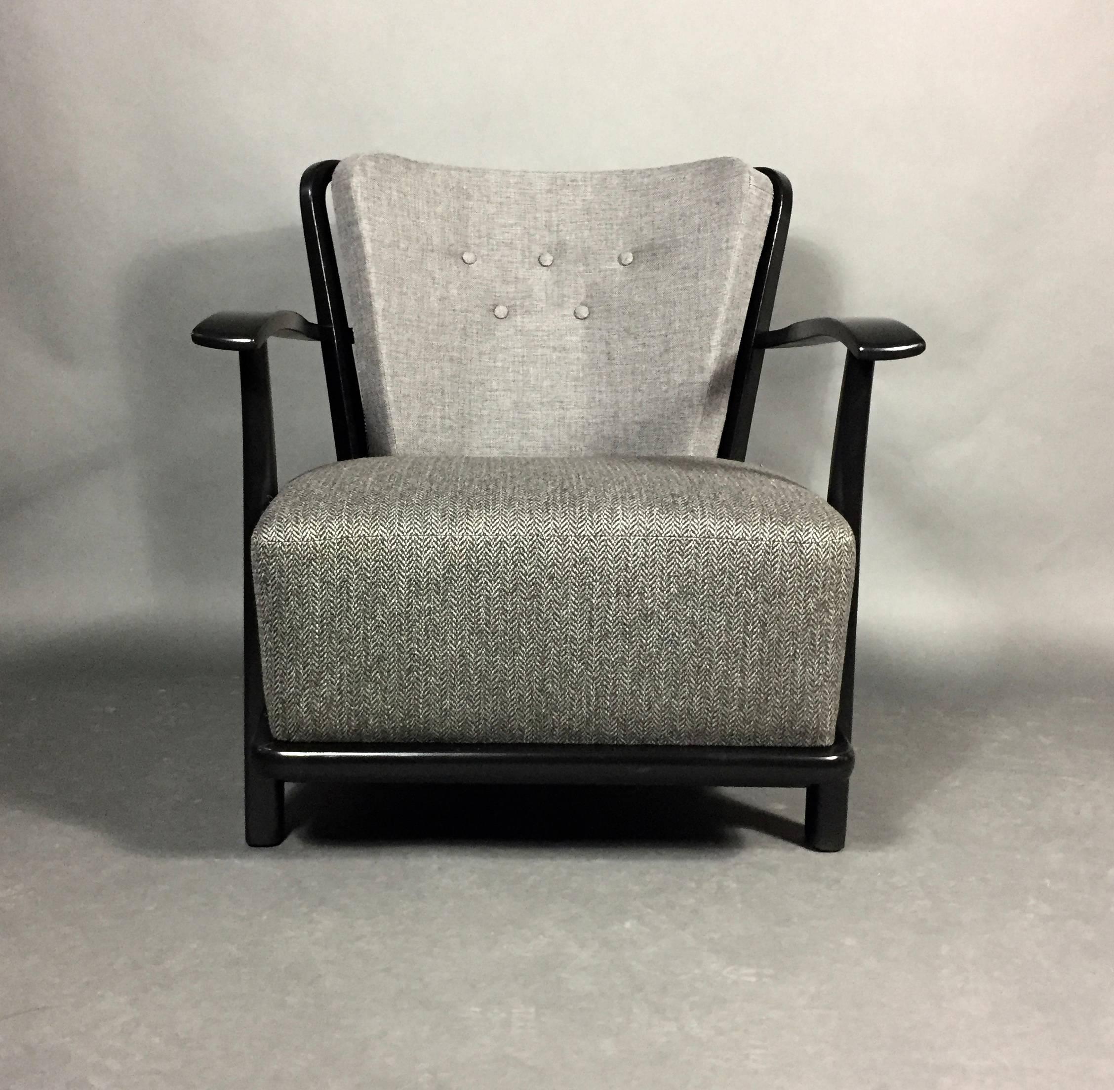 A unique lightness of touch in design makes this chair beautiful from all sides. The deep spring'd seat is complimented by an artfully curved and spindle back. Original birch frame recently updated in black lacquer and contrasting gray buttoned back