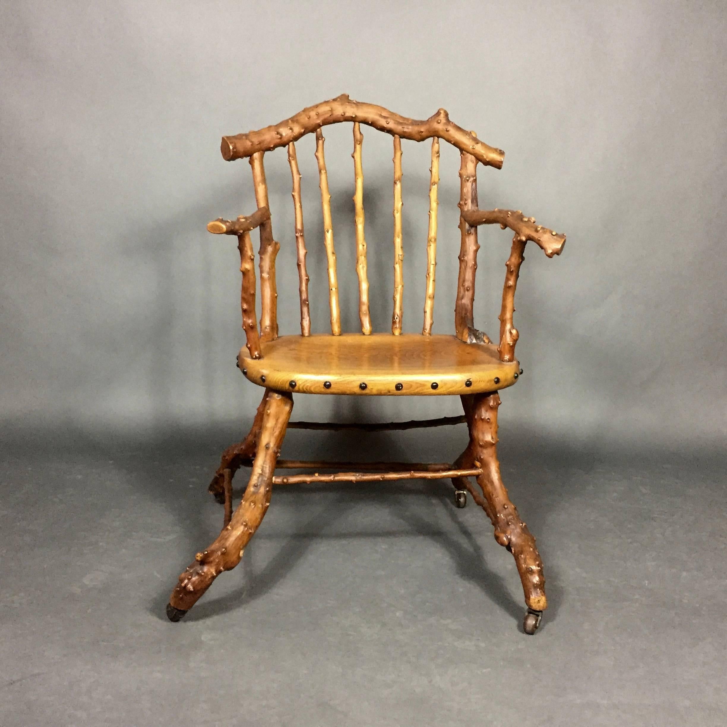 A rare and beautiful example of English, 19th century Victorian Arts and Crafts workmanship - armchair in the Windsor style using knotty yew wood for arms, back and legs - gorgeous polished chestnut seat, original casters. England, mid-1800s.