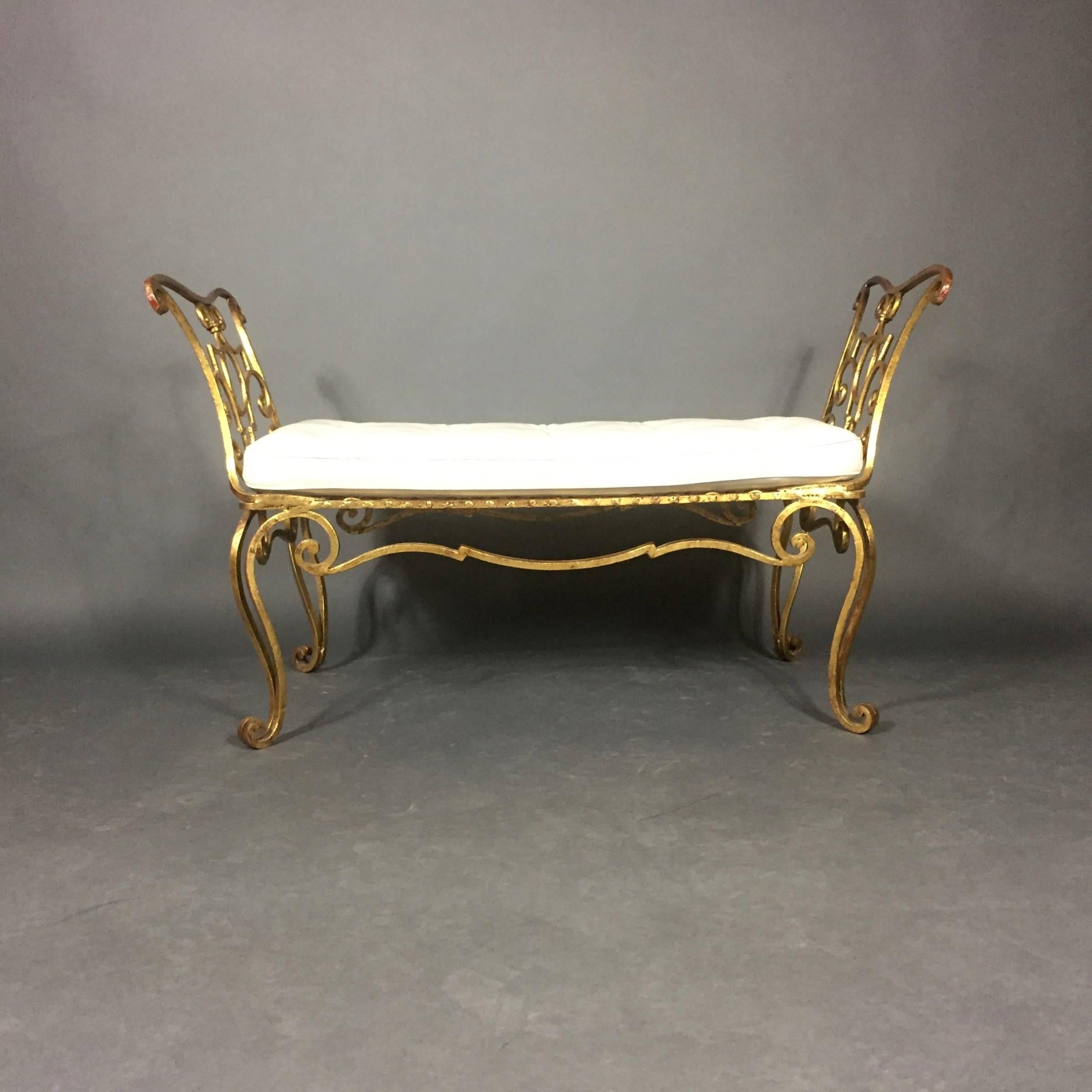 Exceptional detail in this Classic bench by Jean-Charles Moreux with finely shaped and gilded wrought iron over red paint that add richness of color. New and luscious white buttoned leather seating beautifully shaped to match sculpted seat frame,