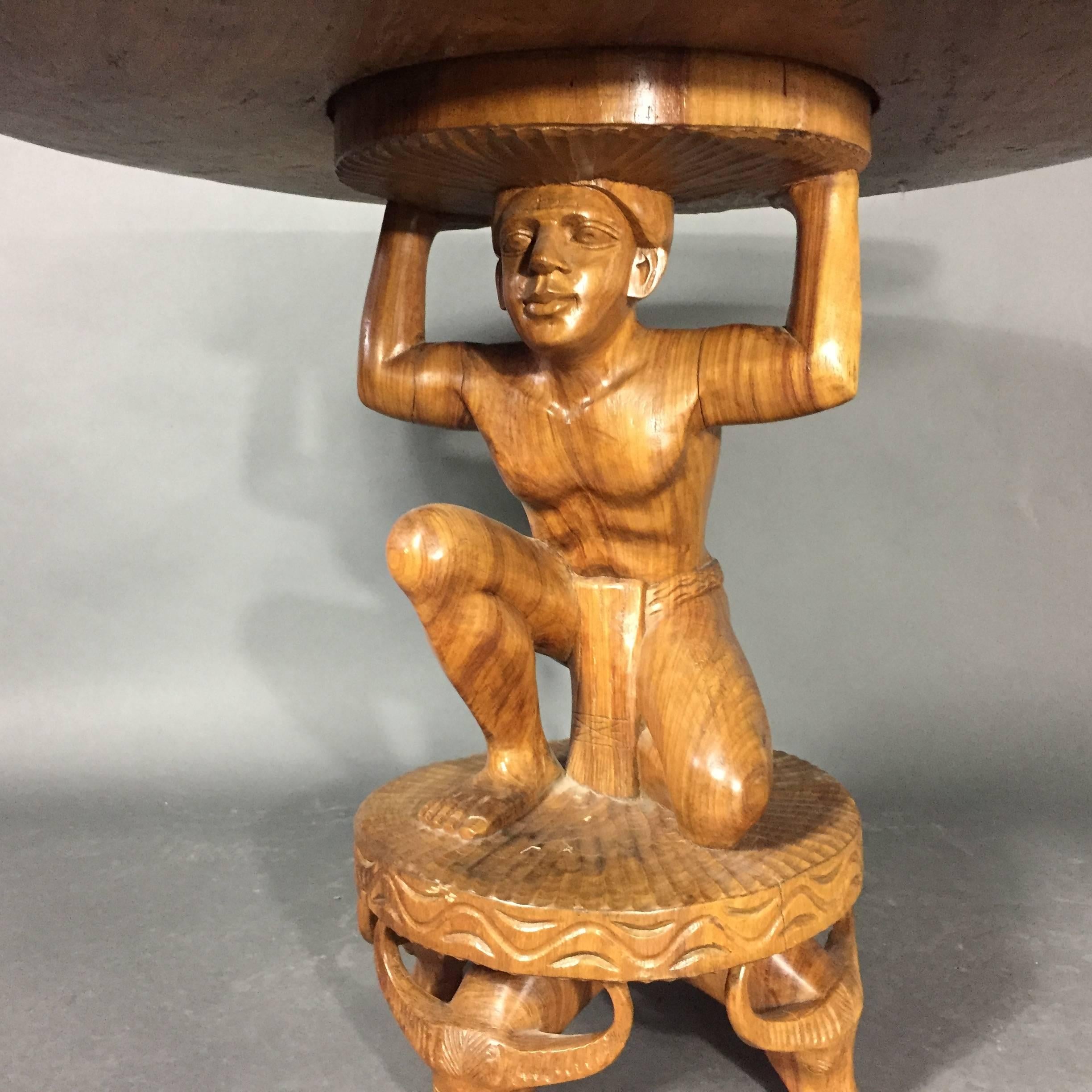 Really quite stunning - this early 1900s 39 inch diameter center table with hand-carved figural base and four steer-head legs has great presence. Top is an impressive one-piece of hardwood with carvings along edge and center. Chip to top edge -