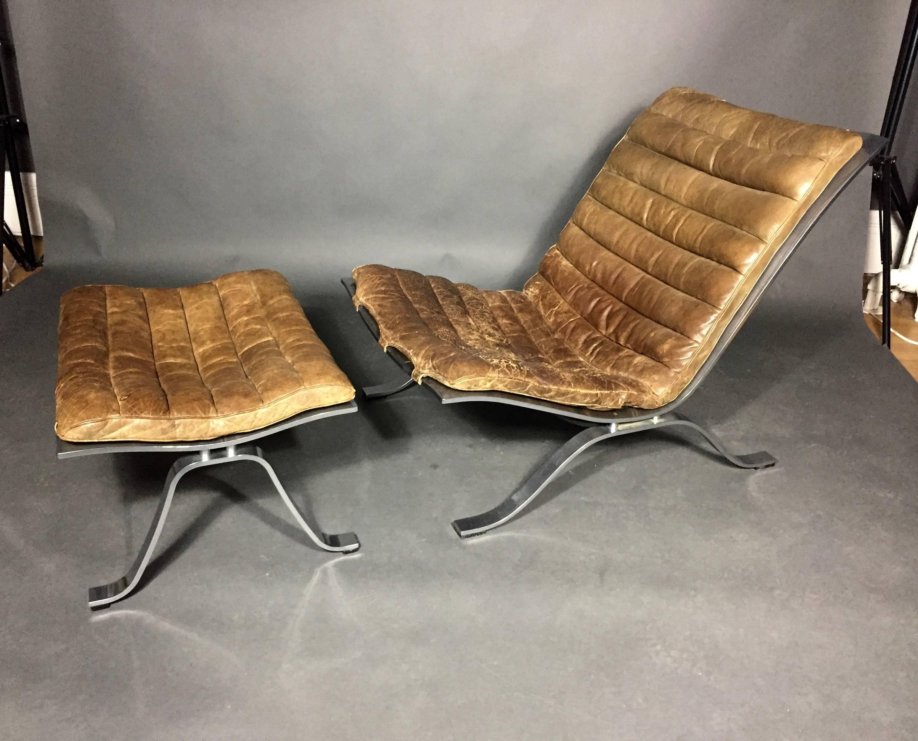 A very sexy original Ari chair and ottoman by Arne Norell in cognac leather and chromed steel. Wonderful vintage condition with normal wear to leather seating. Just spectacular. Möbel AB Arne Norell, Sweden, late 1960s. Original tags to both chair
