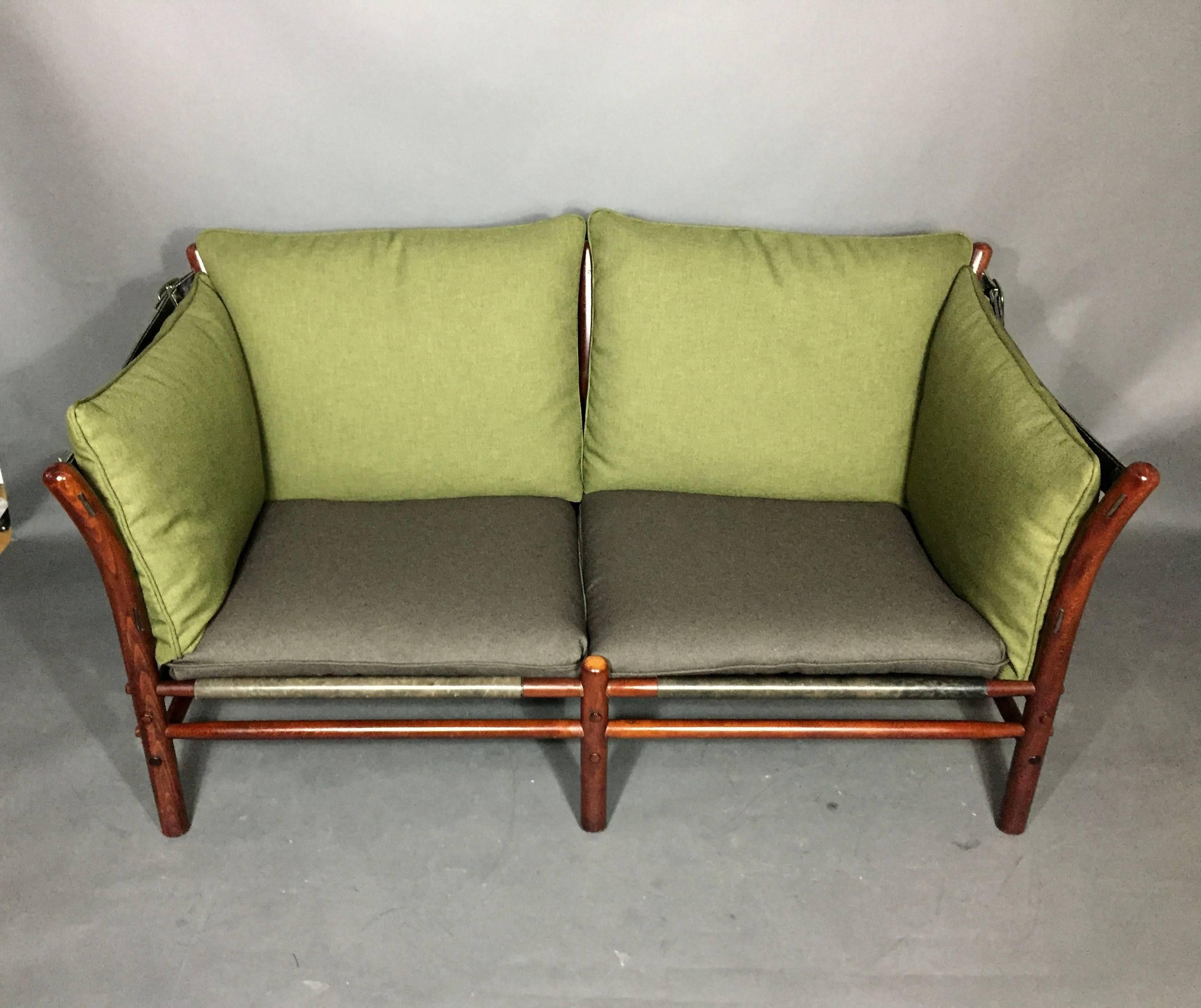 The safari sofa with black saddle leather strapped overall is one of Arne Norell's most admired and SEXY designs. This one has cushions recently updated with Maharam fabric in green/brown. Marked with label - Möbel AB Arne Norell Anby, Sweden.