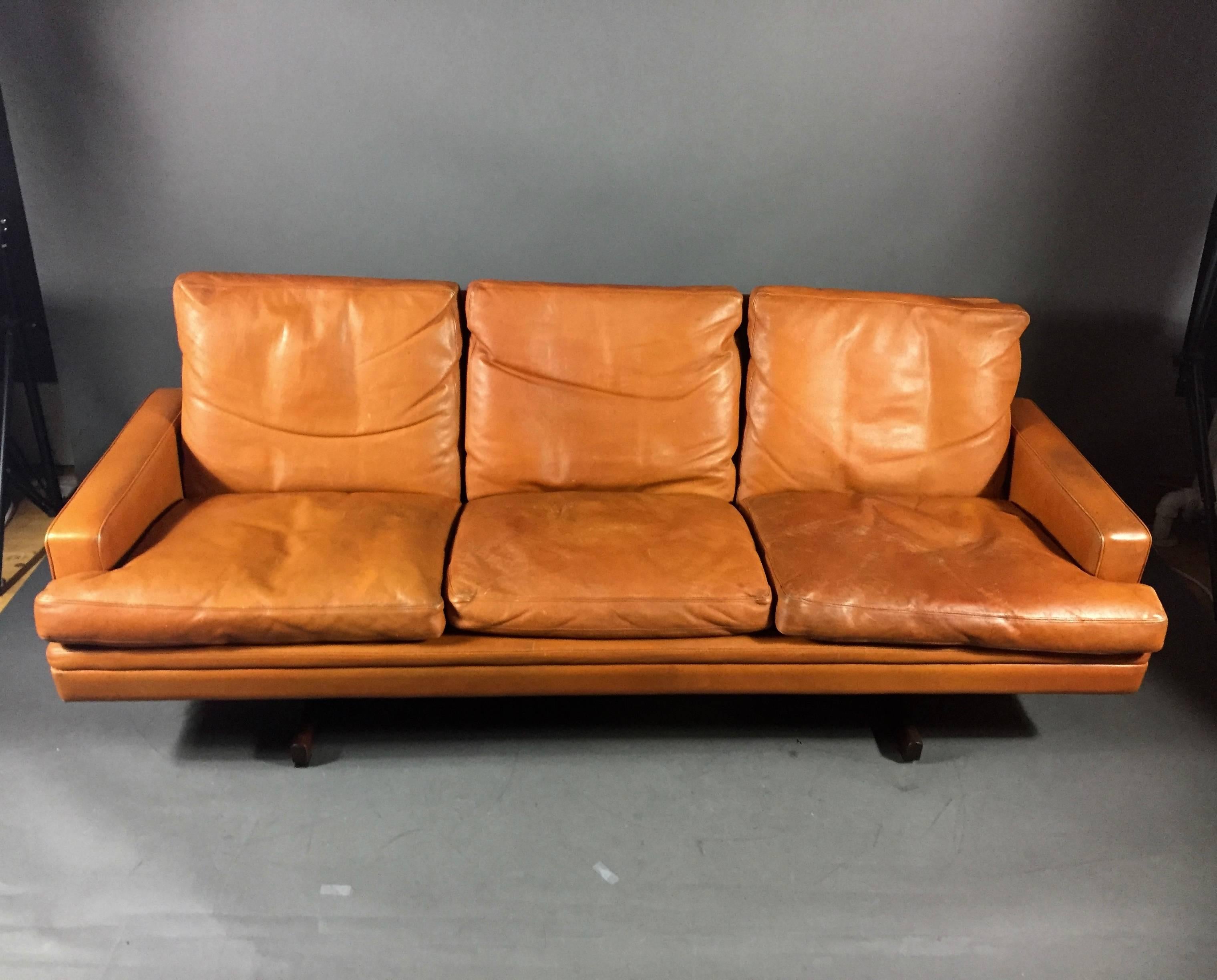 The luscious leather color (somewhere between rust orange, brown and red) on this sofa designed by Fredrik A. Kayser for Vatne Møbler in 1960s. Six loose down cushions for ultimate comfort. Rosewood T-frame legs. Perfect patina. Norway. Marked with