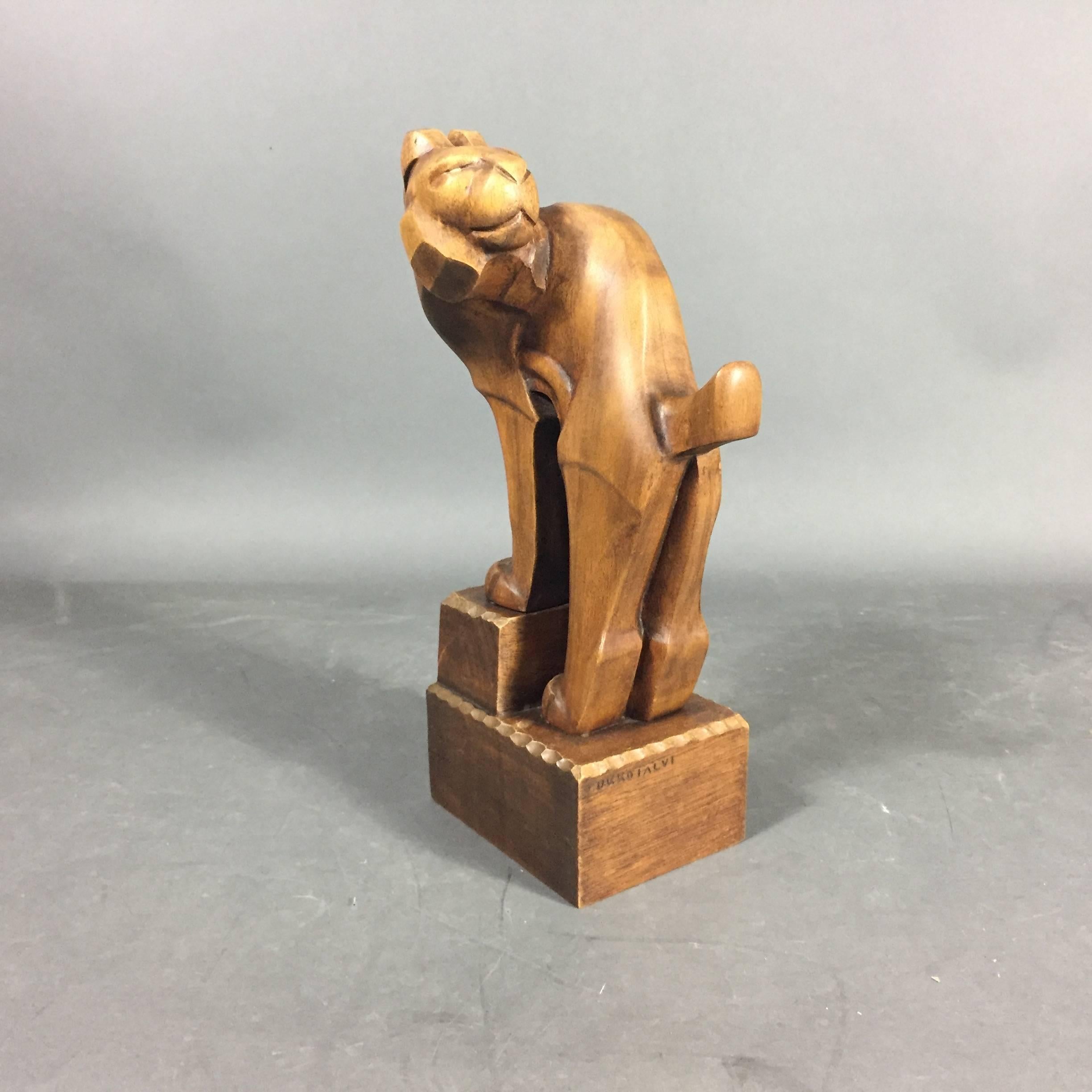 Graceful and powerful Art Deo period carved wood sculpture of a stylized lion by Finish artist Ukko Talvi from the 1920s. Signed.