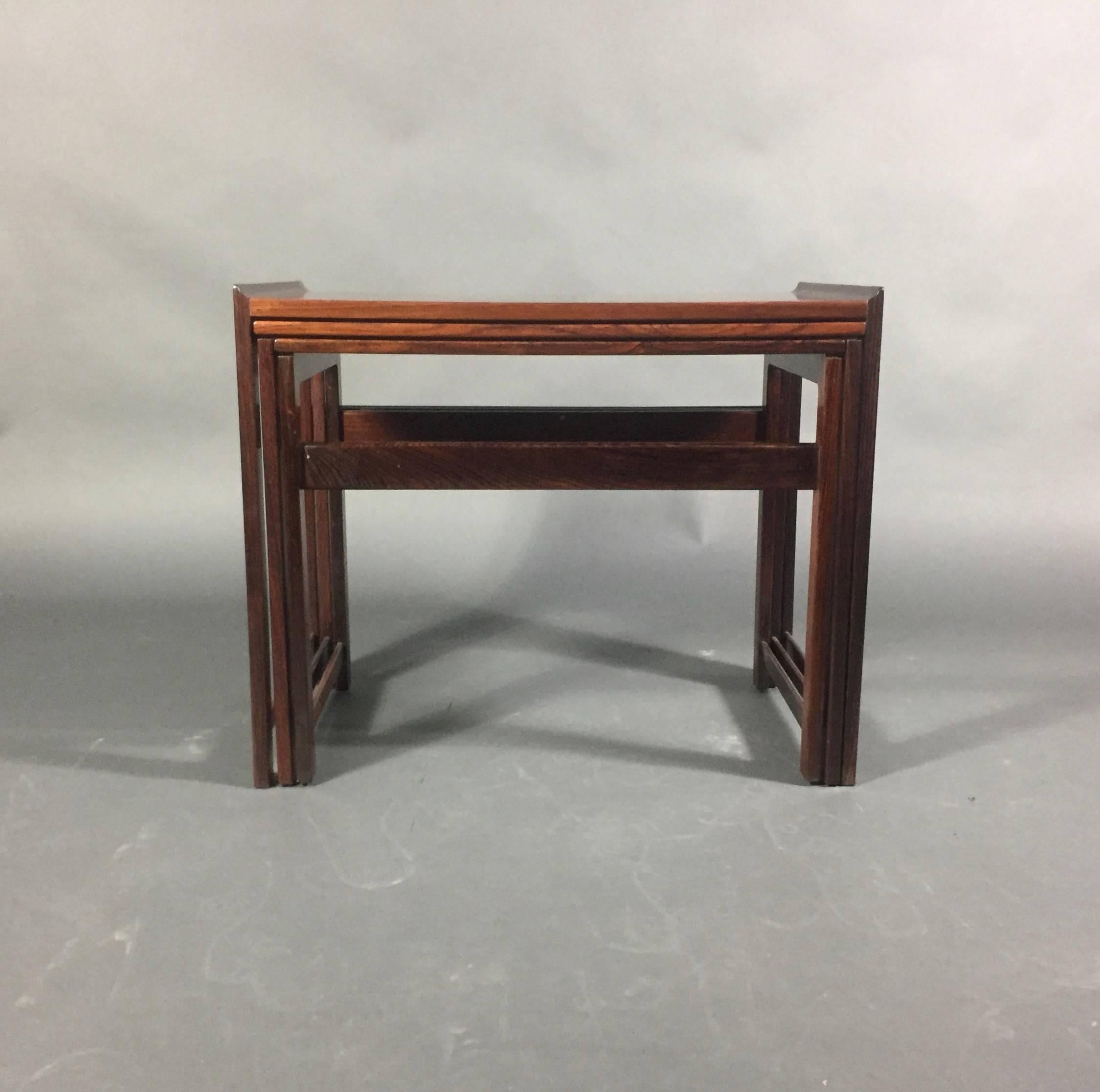 An elegant set of three nesting tables in a classic rosewood with flared ends. Danish design, early 1970s. Refinished condition.