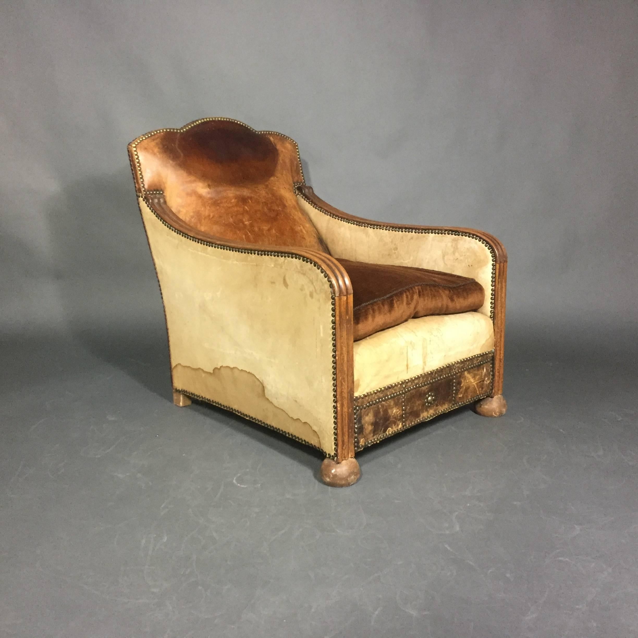 Art Deco at its clubby best. Leather armchair attributed to Otto Schultz from the 1930s with sculpted wood arms that extend to the base at front and crowned seat back. The chair is trimmed in brass tacks with a classic Schultz design to the front.