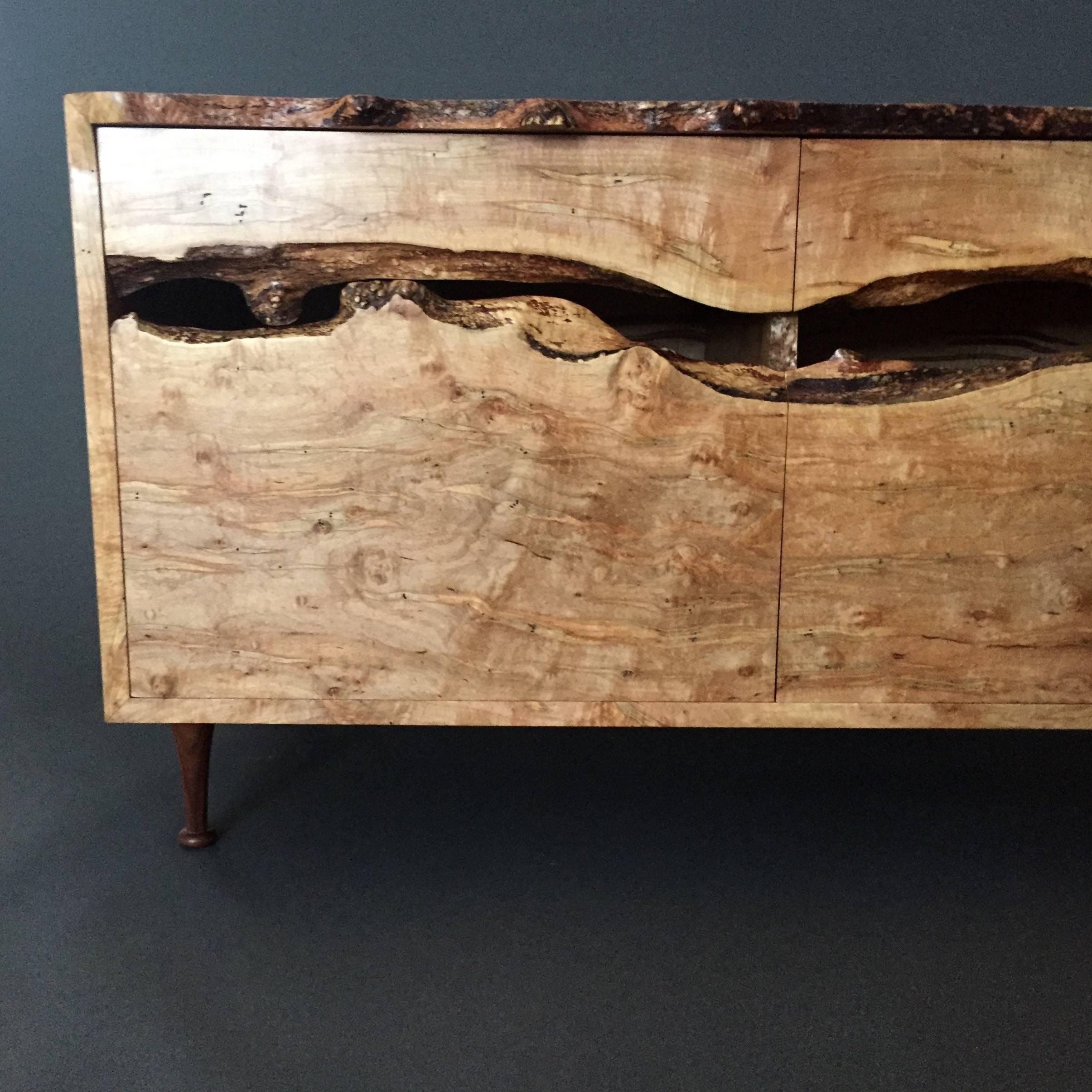 This is a one-of-a-kind cabinet by artist Daniel Oates, executed in his Sharon CT studio in a spectacular ambrosia maple including two live-edge drawers, doors and interior shelves. Legs are hand-turned walnut with internal steel reinforcement,