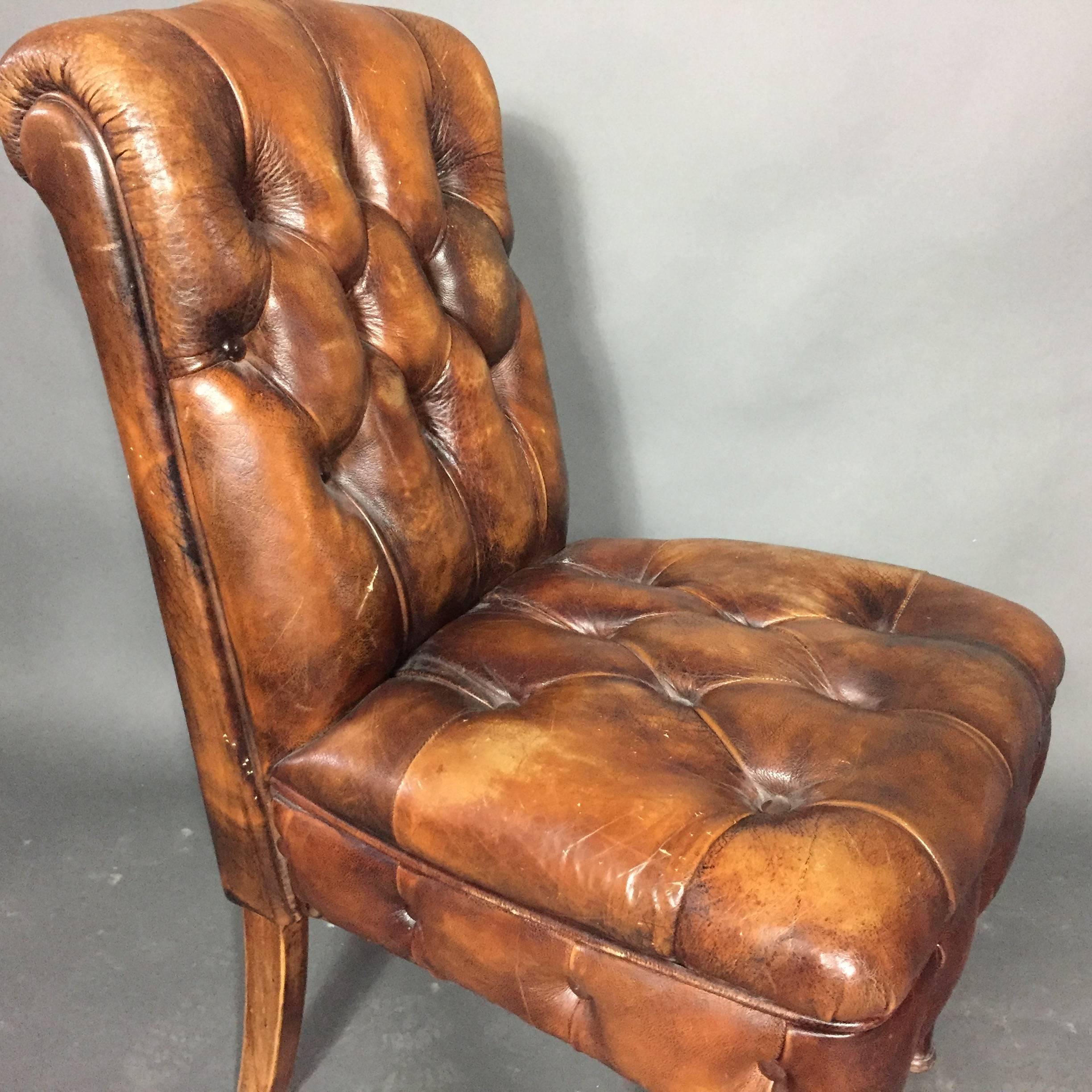 A rather sweet English slipper chair in the Chesterfield style from the 1920s professionally later re-leathered. Wonderful patina. Newer front legs.