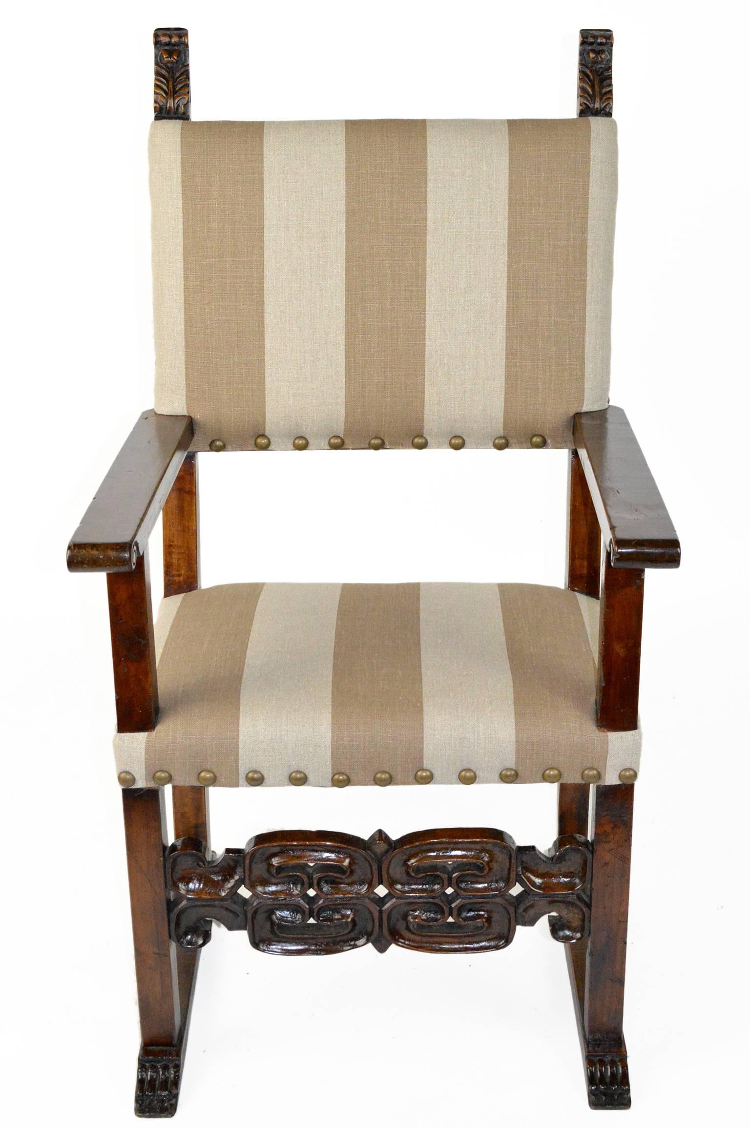 Pair of Italian walnut throne chairs with intricately carved stretcher and finials.
