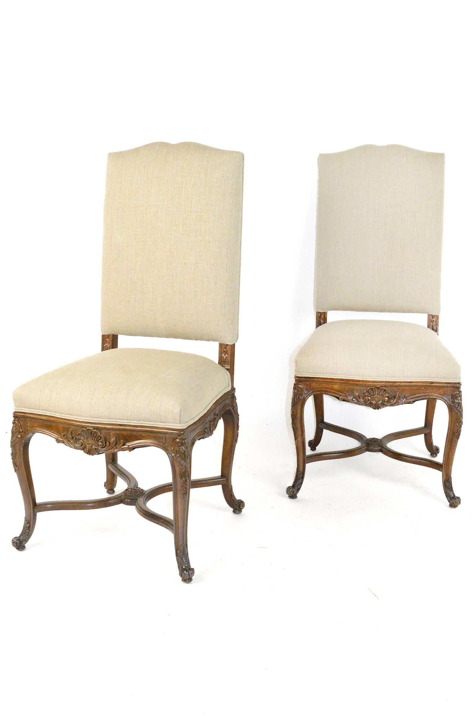 Set of eight Louis XV style dining chairs having foliate carved sides, back and acanthus carving at skirt supported by cross frame stretcher joined by central floral medallion.