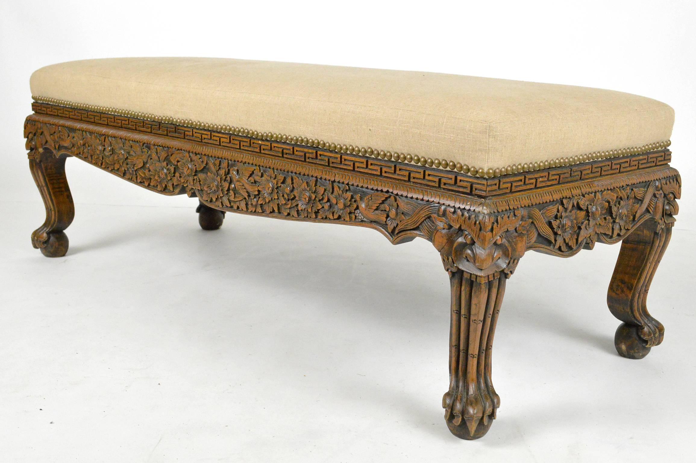 Asian carved teak wood bench beautifully carved throughout, newly covered in linen with nailhead trim.
