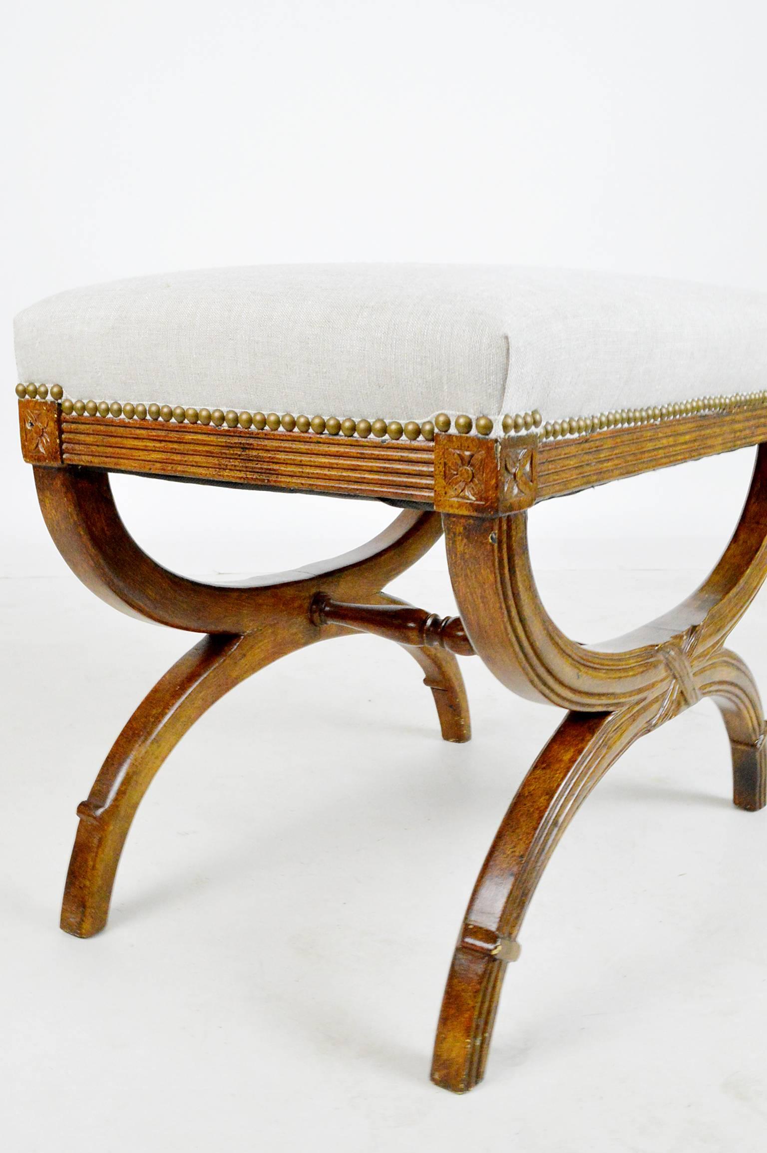 Regency style stool with carved trim, turned stretcher and linen upholstery, mid-20th century.