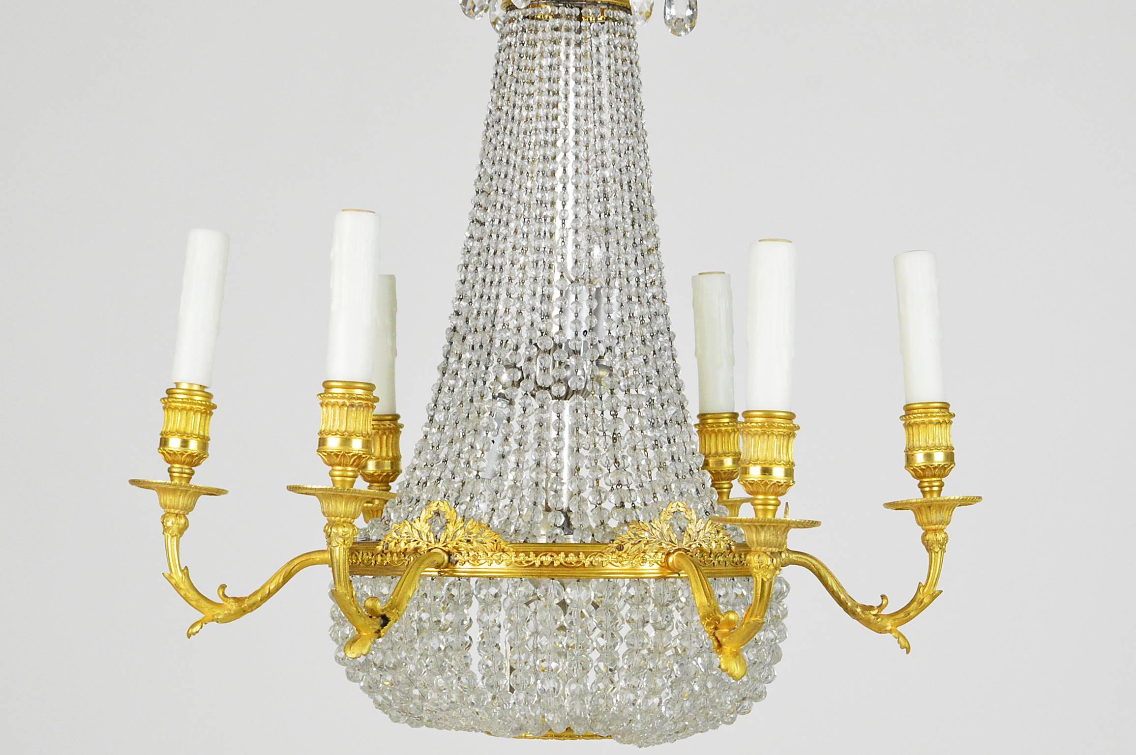 French Empire style gilt bronze and beaded six-light chandelier attributed to E.F. Caldwell, NY having a basket-shaped beaded glass body and foliate bronze designs along the crown and arms. Having its original gold-plated ceiling medallion for