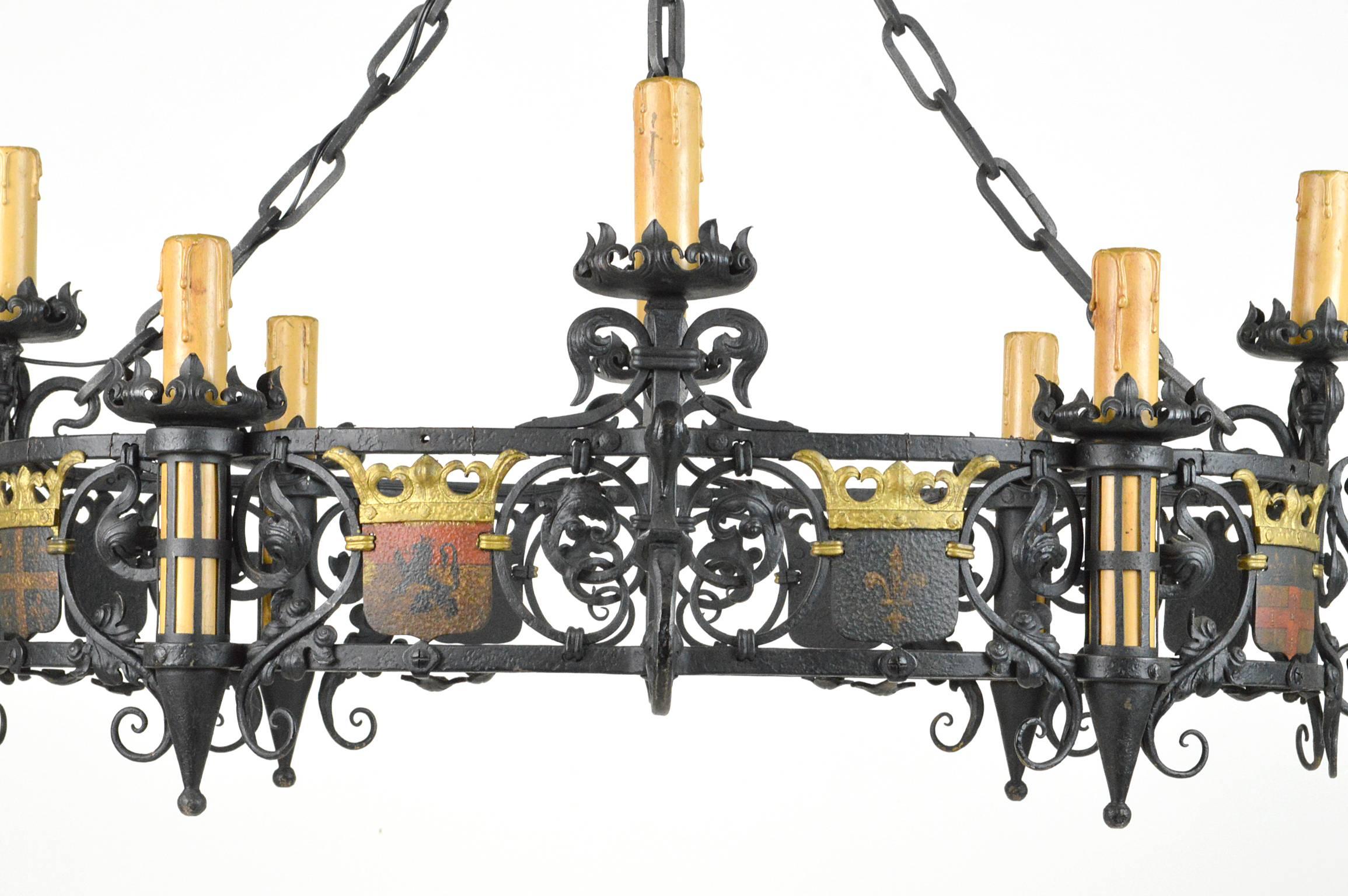 19th century French iron and polychrome painted eight-light chandelier having eight heralded shields suspended between foliate scrolls, hanging from a Corona form and fleur de lis canopy. Completely re-wired.