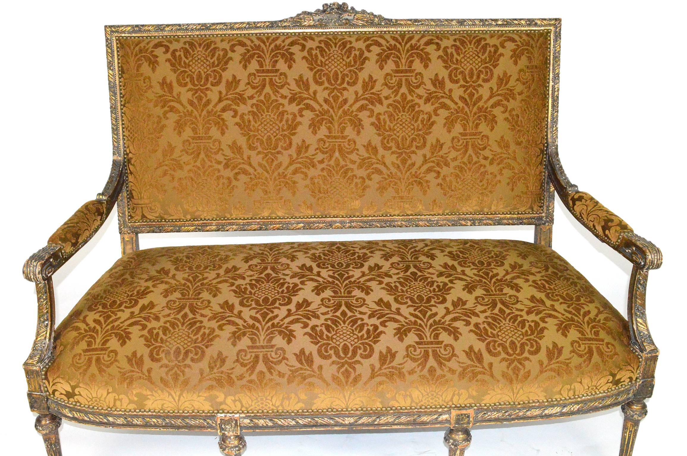 19th century French Louis XVI style carved and painted gilt settee with damask tapestry.