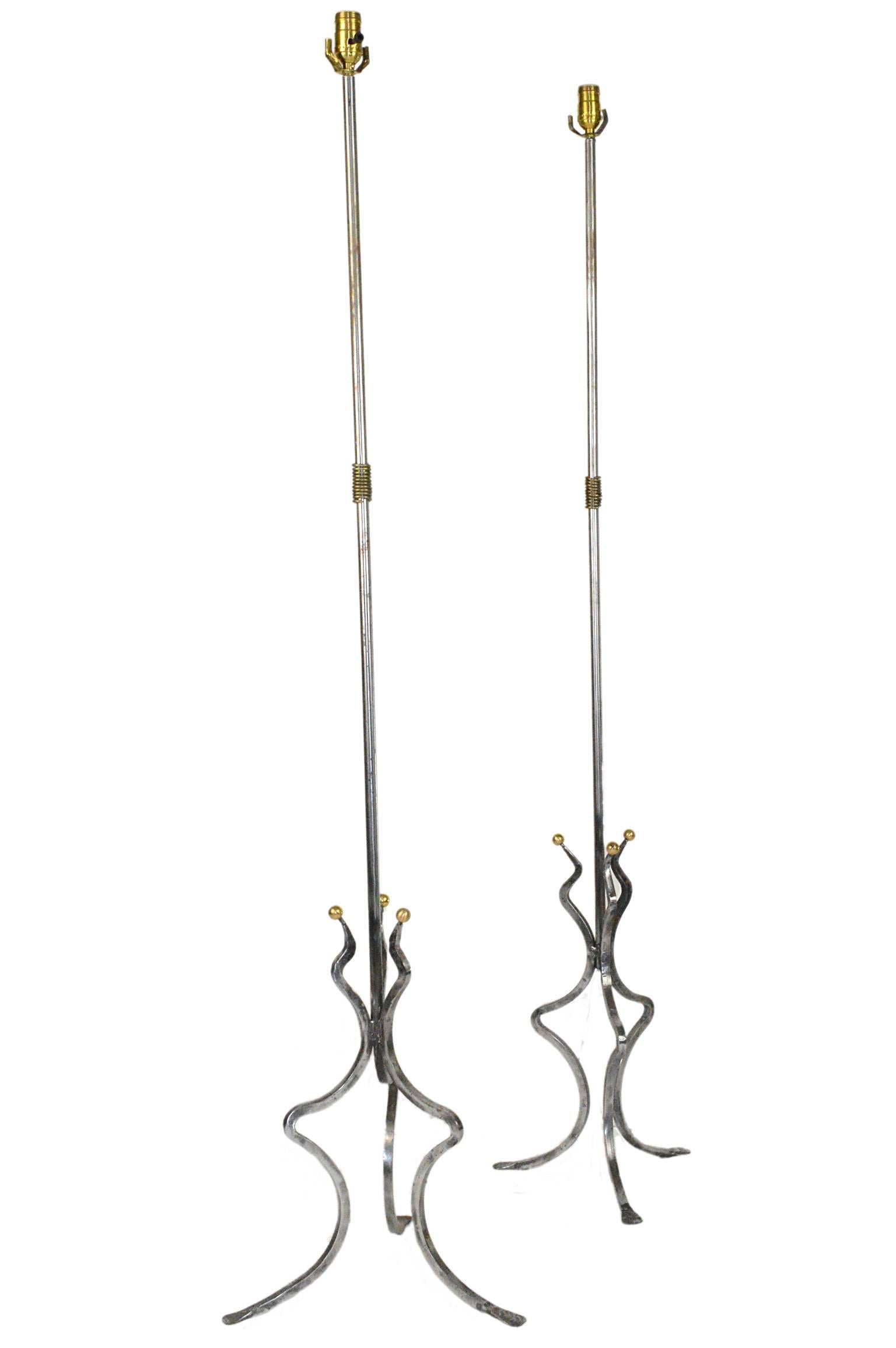 Pair mid century steel polished and brass accents floor lamps on tripod legs.

Smallest measures 62.5