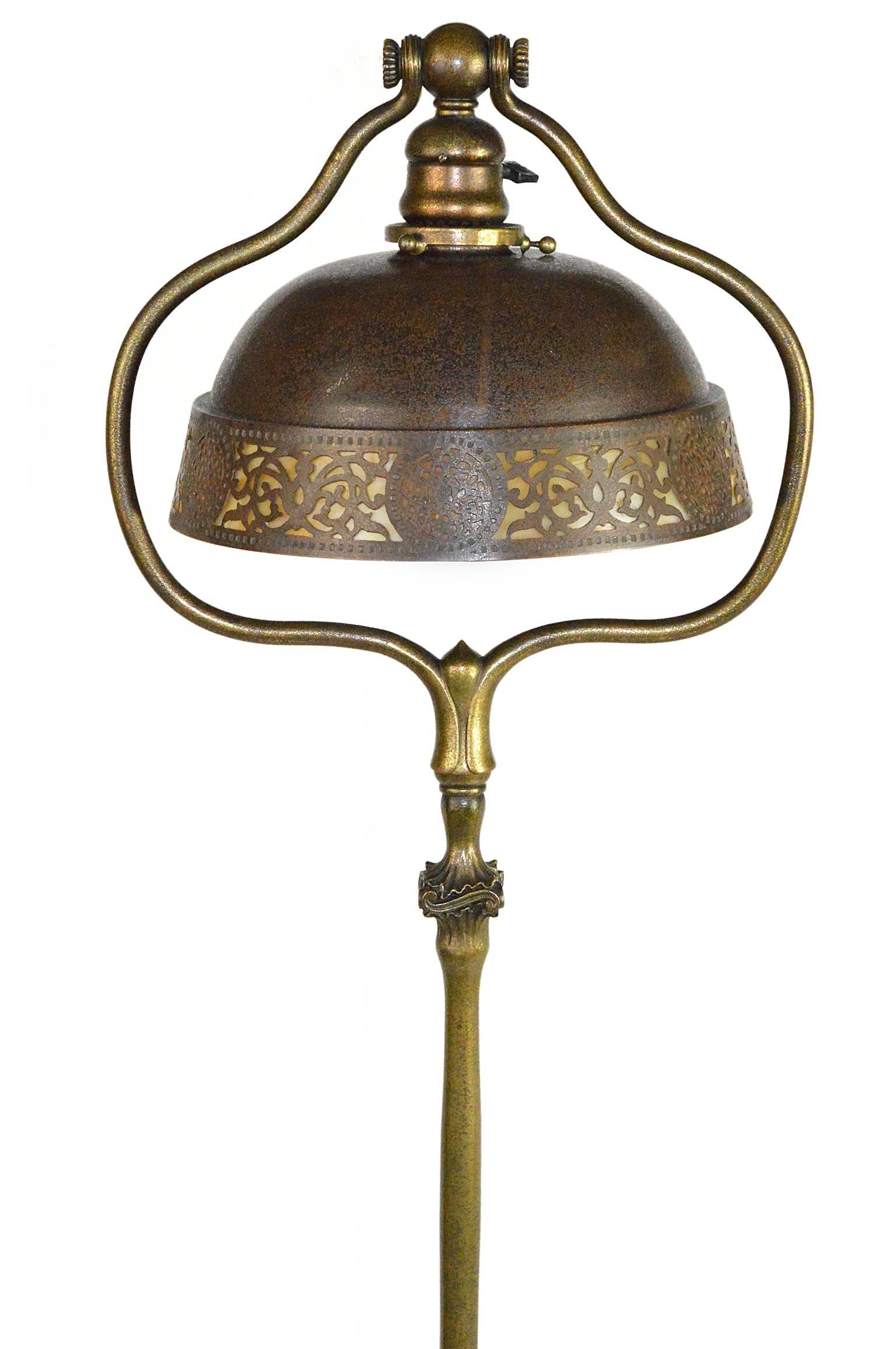 Tiffany Studio bronze floor lamp with bronze and glass shade. Gilt bronze base with four panel metal supports on stepped circular base. Stamped 