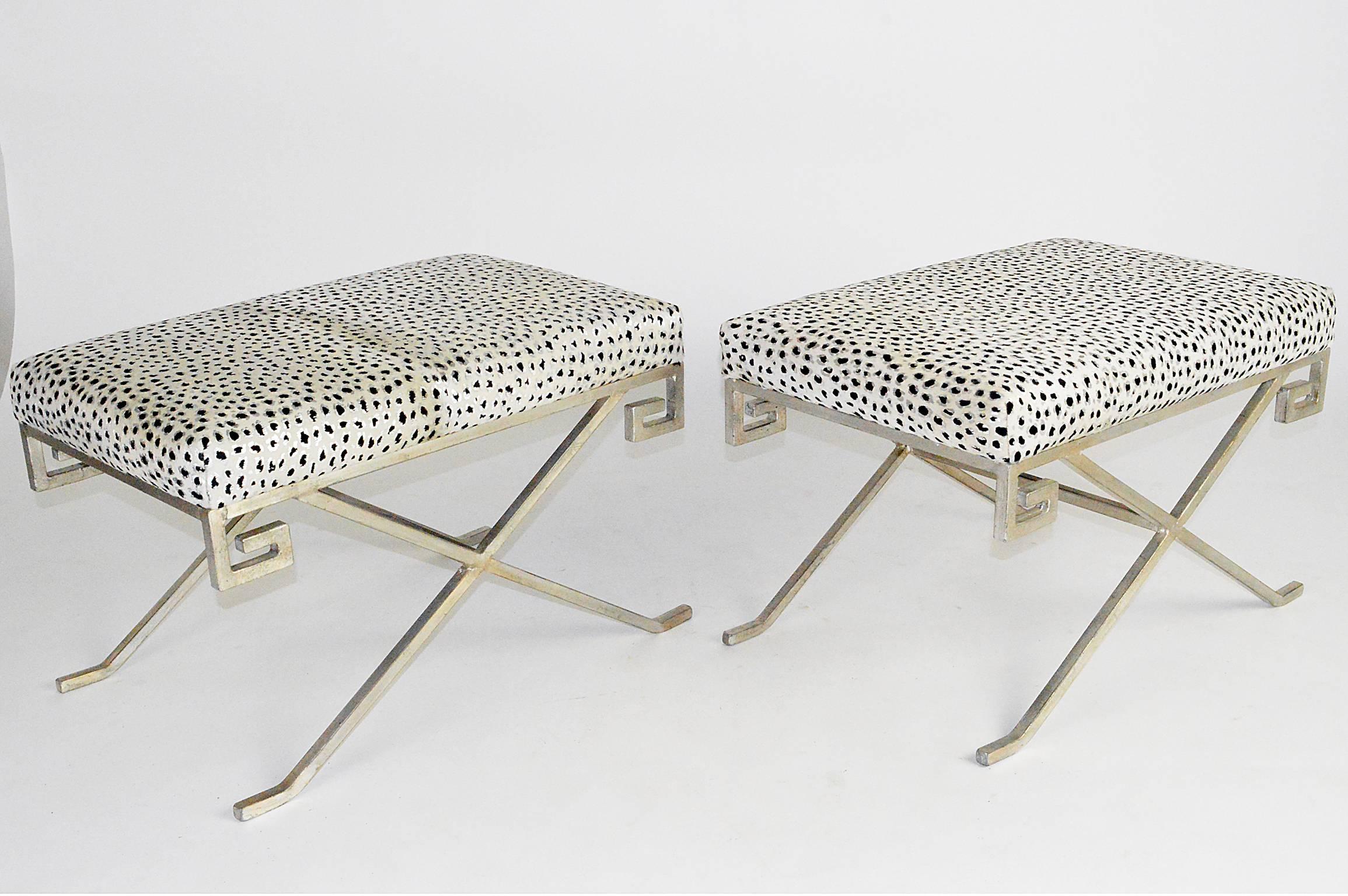 Pair of silver leaf steel benches of X-form and Greek key apron in the style of Jean Michel Frank covered in a painted silver leaf white cowhide.