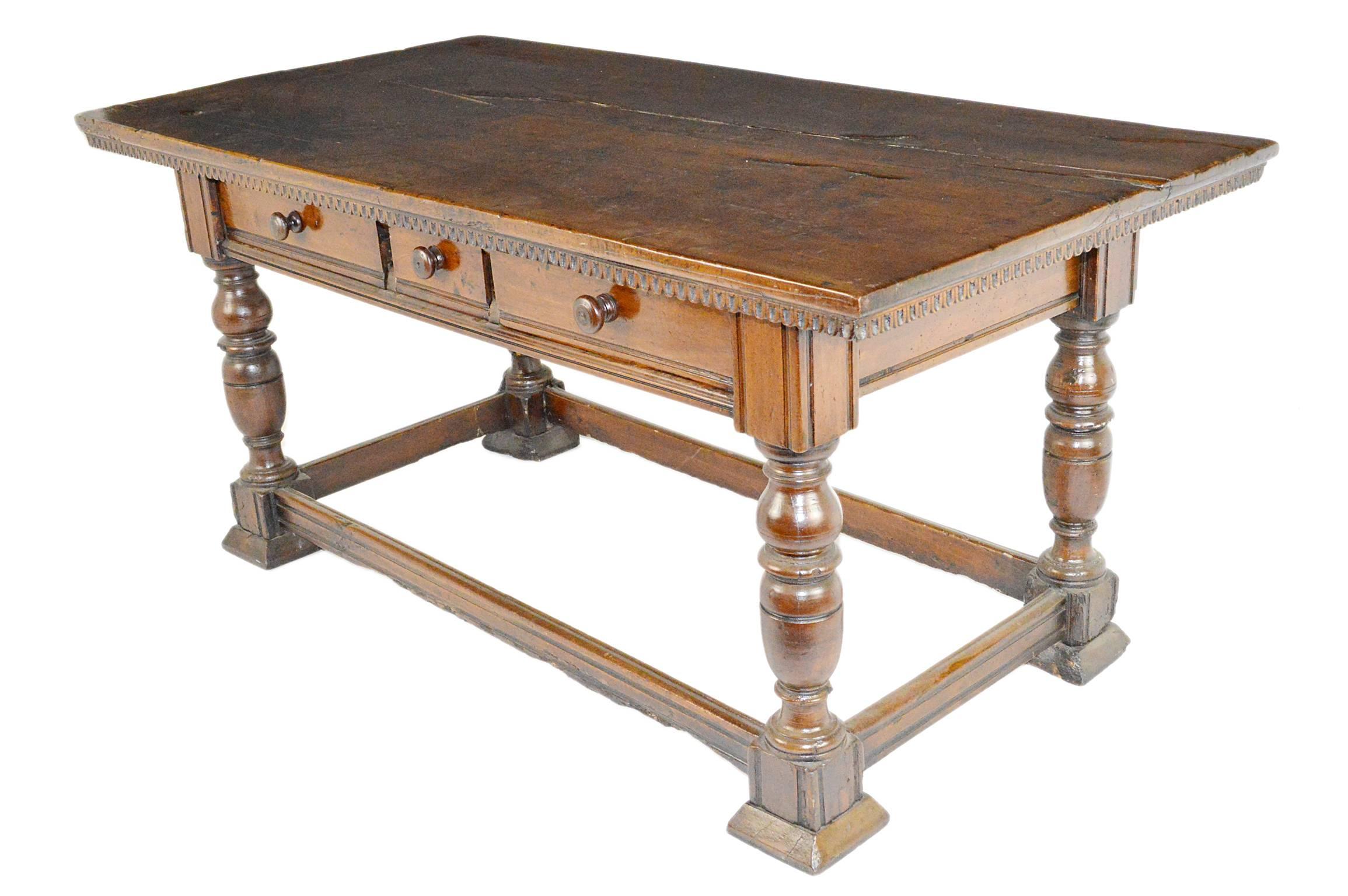 17th-18th century Tuscan walnut table. Having a rectangular top above a frieze of three drawers, Raised on four turned legs, with perimeter stretcher. A gorgeous table, with rich warm patina throughout.