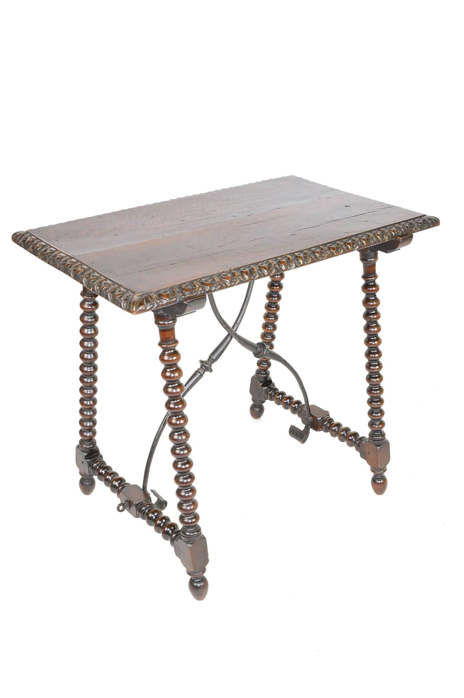 19th century Italian walnut trestle table with its base joined by a wrought iron stretcher and a rich warm patina.