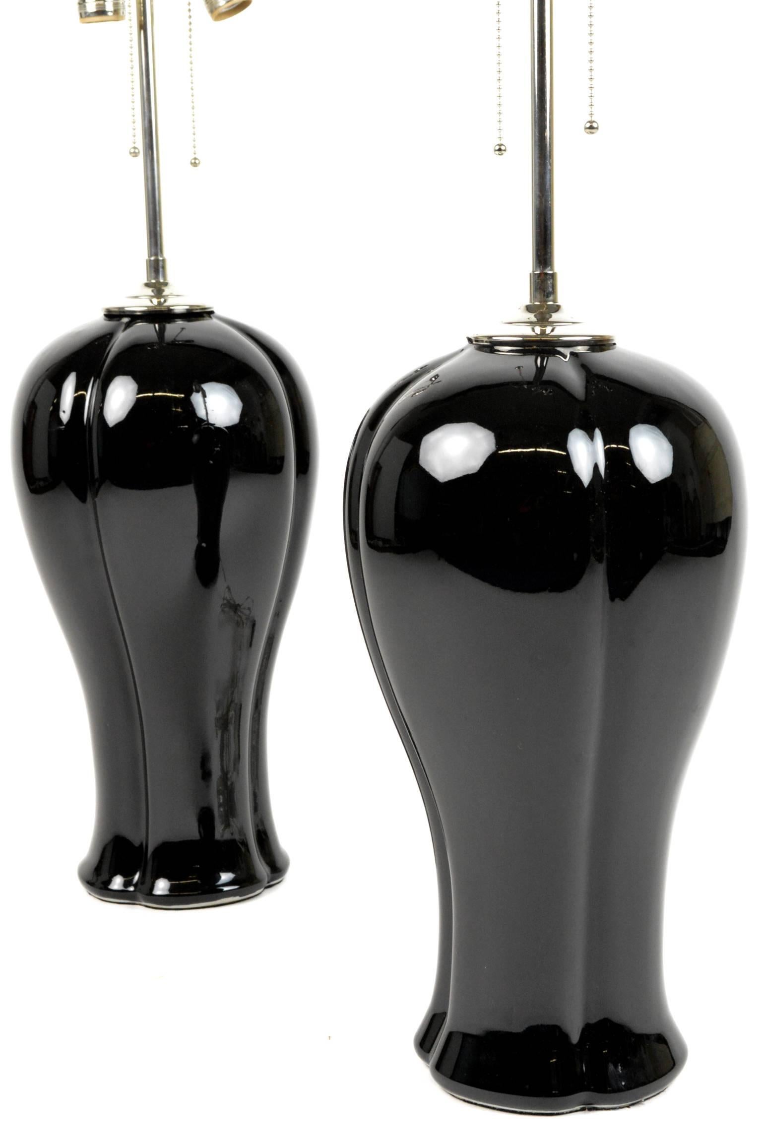 Pair of elegant table lamps with sleek forms in black glazed ceramic with silver plated mounts. Rewired.
27