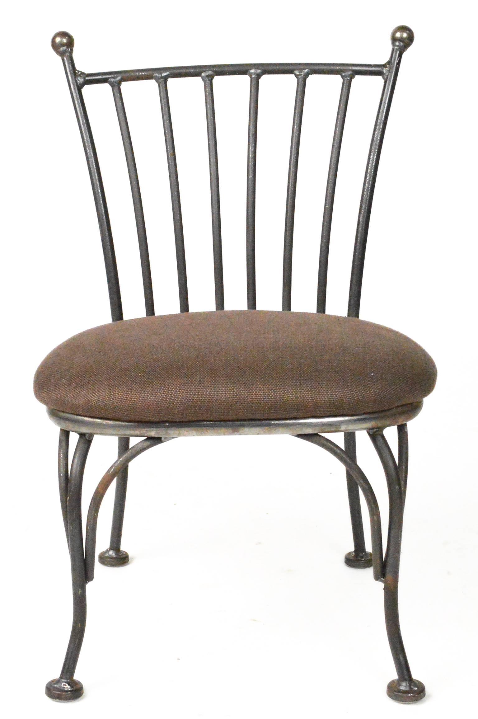 Pair of child's iron bistro chairs with brown tweed upholstery.
