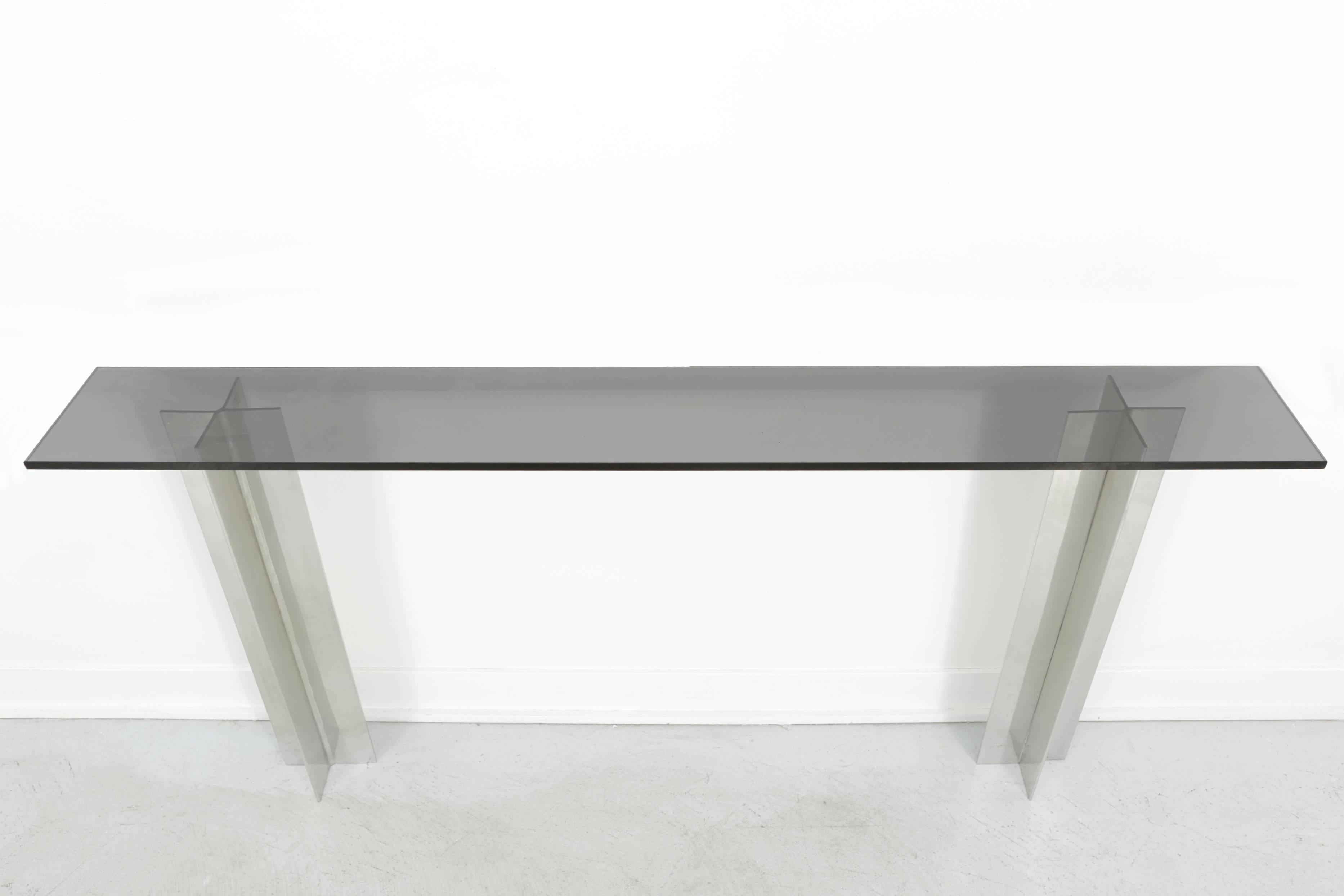 Smoked glass and aluminium console table attributed to Pace Manufacturing. The smoked glass rests upon two aluminium pillars. The console is meant to rest upon a wall.