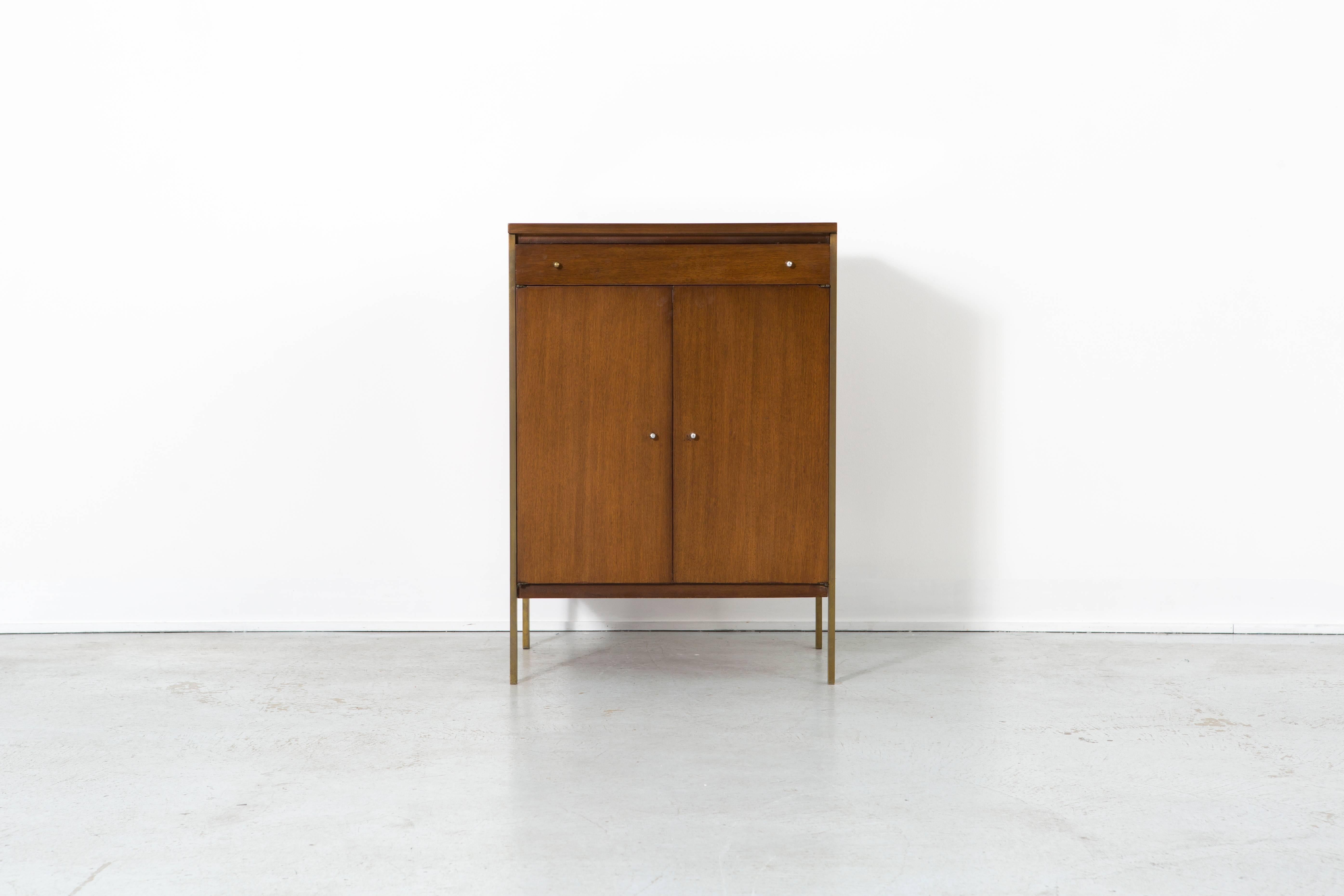 Paul McCobb magnetic-pull cabinet

Connoisseur collection by Paul McCobb

designed by Paul McCobb for H. Sacks + Sons Brookline Mass

USA, circa 1950s

walnut and brass

cabinet is pictured with Paul McCobb's eight-shelf cabinet which is