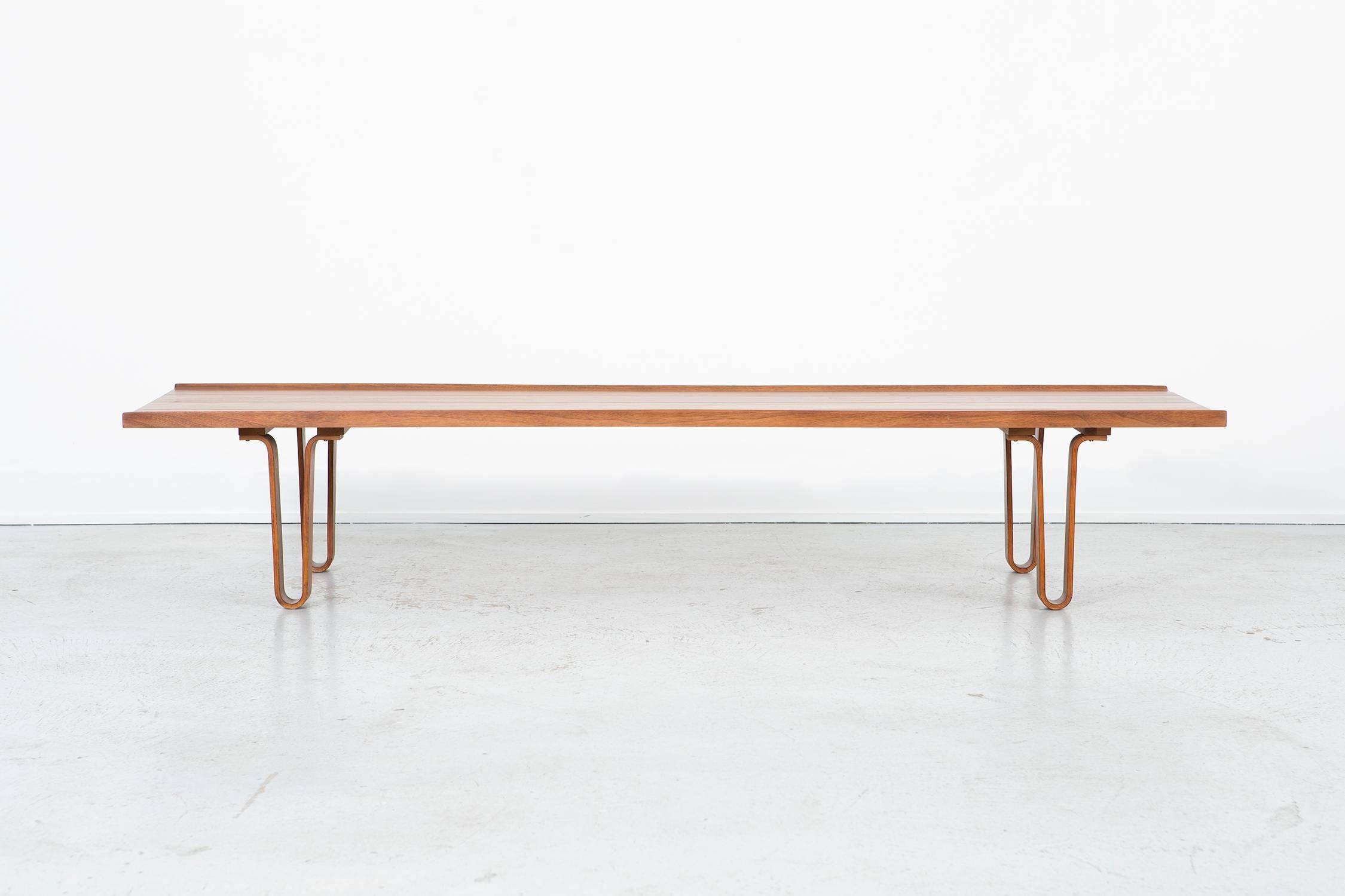 Long John bench or coffee table 

designed by Edward Wormley for Dunbar

USA, circa 1950s

refinished walnut

Measure: 13 5/16” H x 70” W x 19” D x seat 12” H.