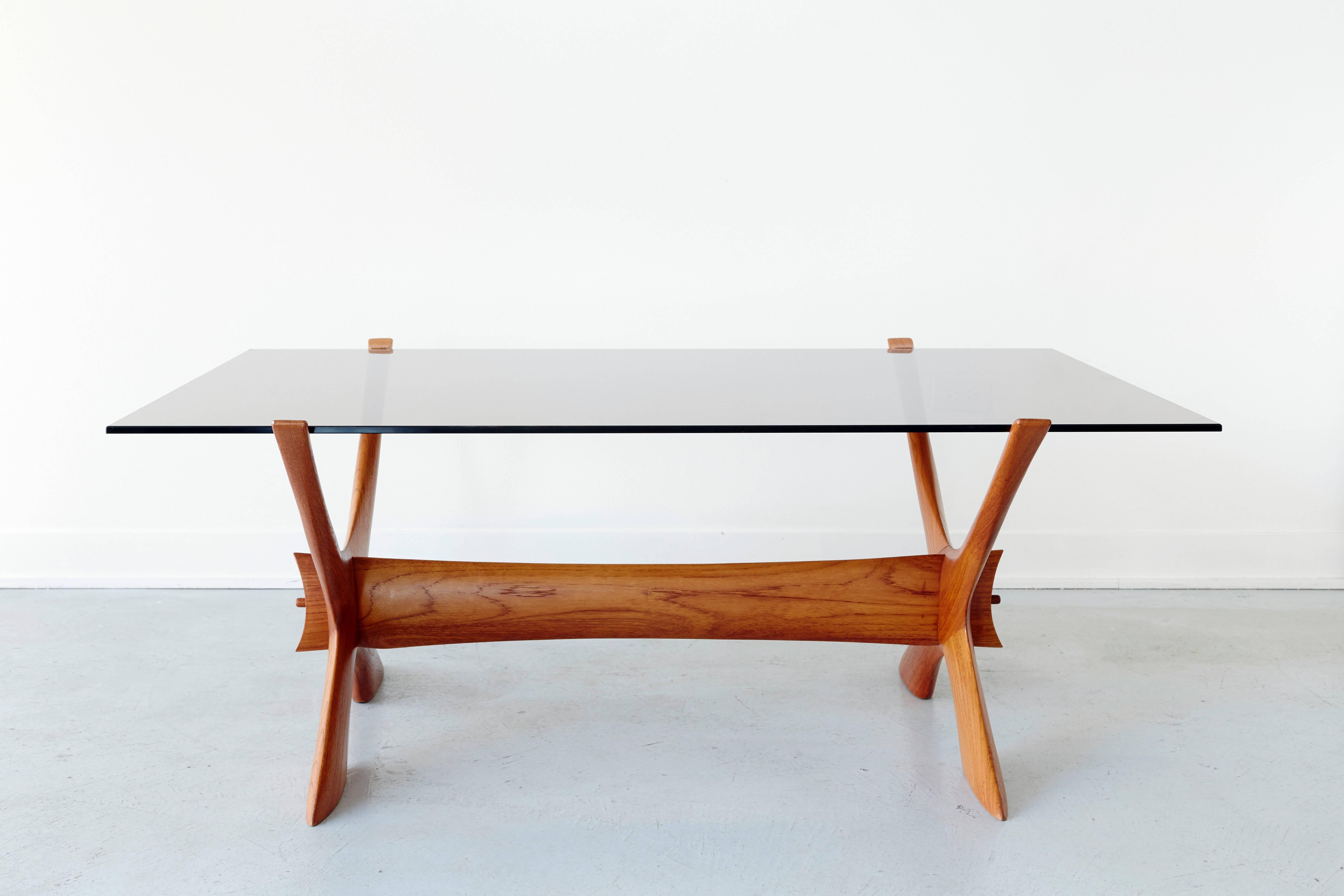 Illum Wikkelsø sculptural coffee table in teakwood. Mint original condition. Glass top has a blue smoked tint.