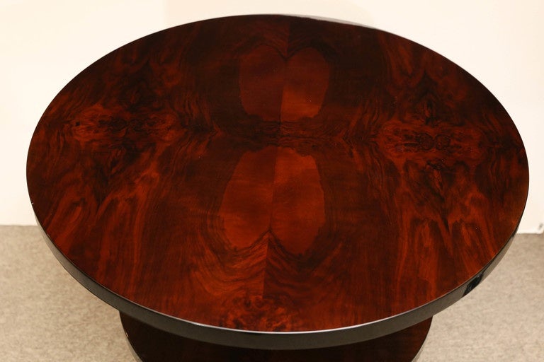 This round side table is constructed from one main supporting leg that holds round top, bottom and a shelf in the middle. Wide and highly polished top of the table displayed beauty of the rosewood. Despite the small size of the base, the table is