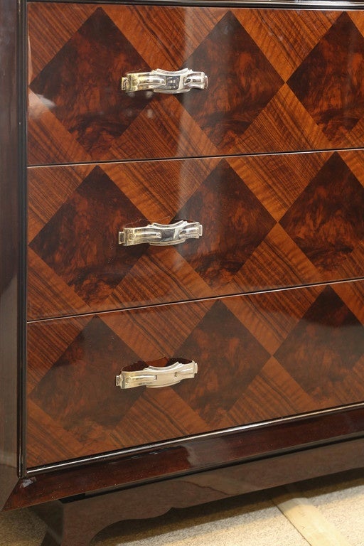 This exceptional chest has a main frame that is juxtaposed to 3 drawers to emphasize difference of wood design. On the edges of the main frame is a thin chrome trimming, that is accentuates its corners. Each drawer has 2 chrome handles on its sides.