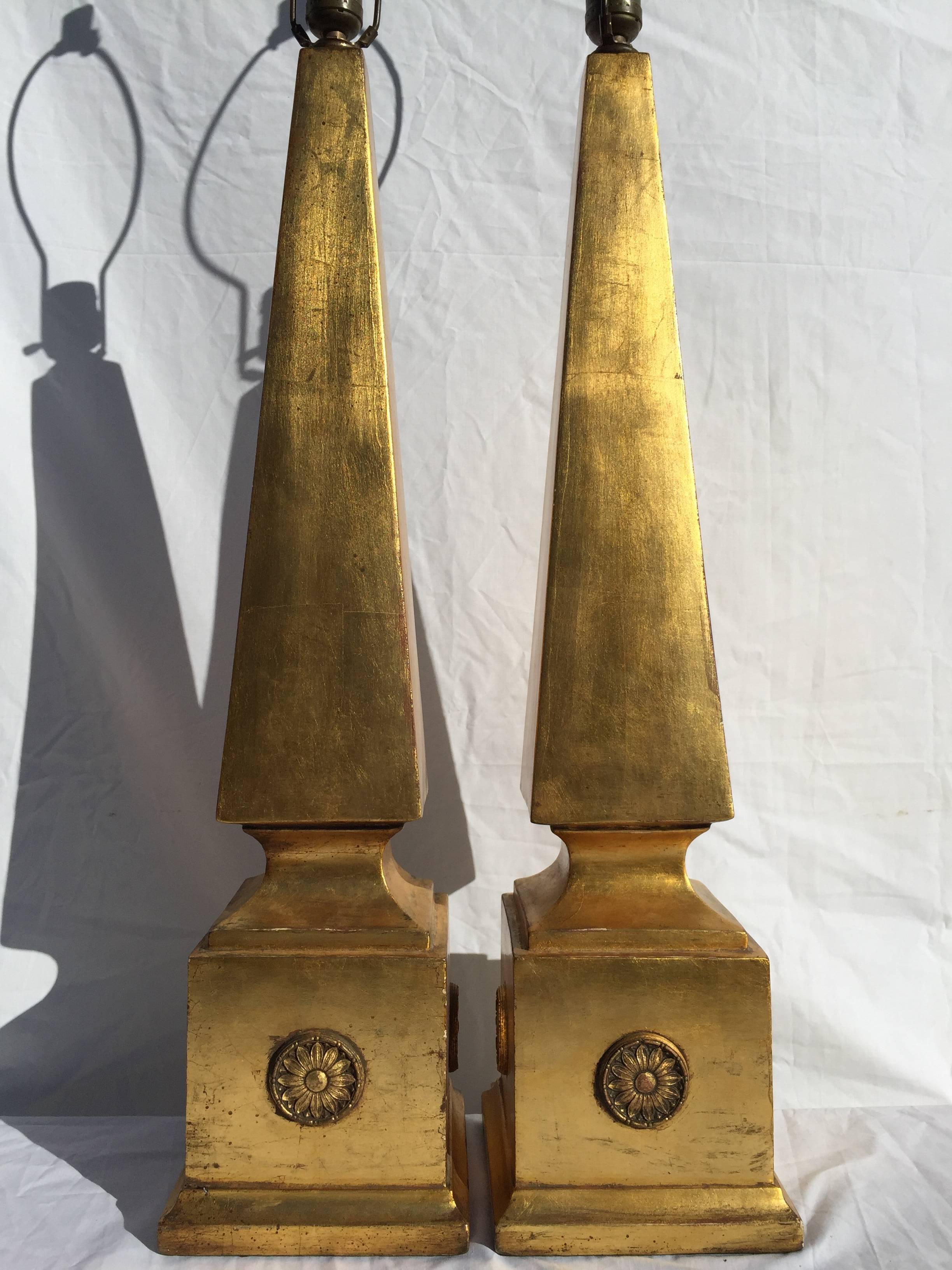 Let there be light and sunflowers and a Classic form. This pair of lamps has a scale quite grand, a commanding presence and a gilt finish over what I believe to be plaster. The bases are square and decorated with sunflower medallions on each of the