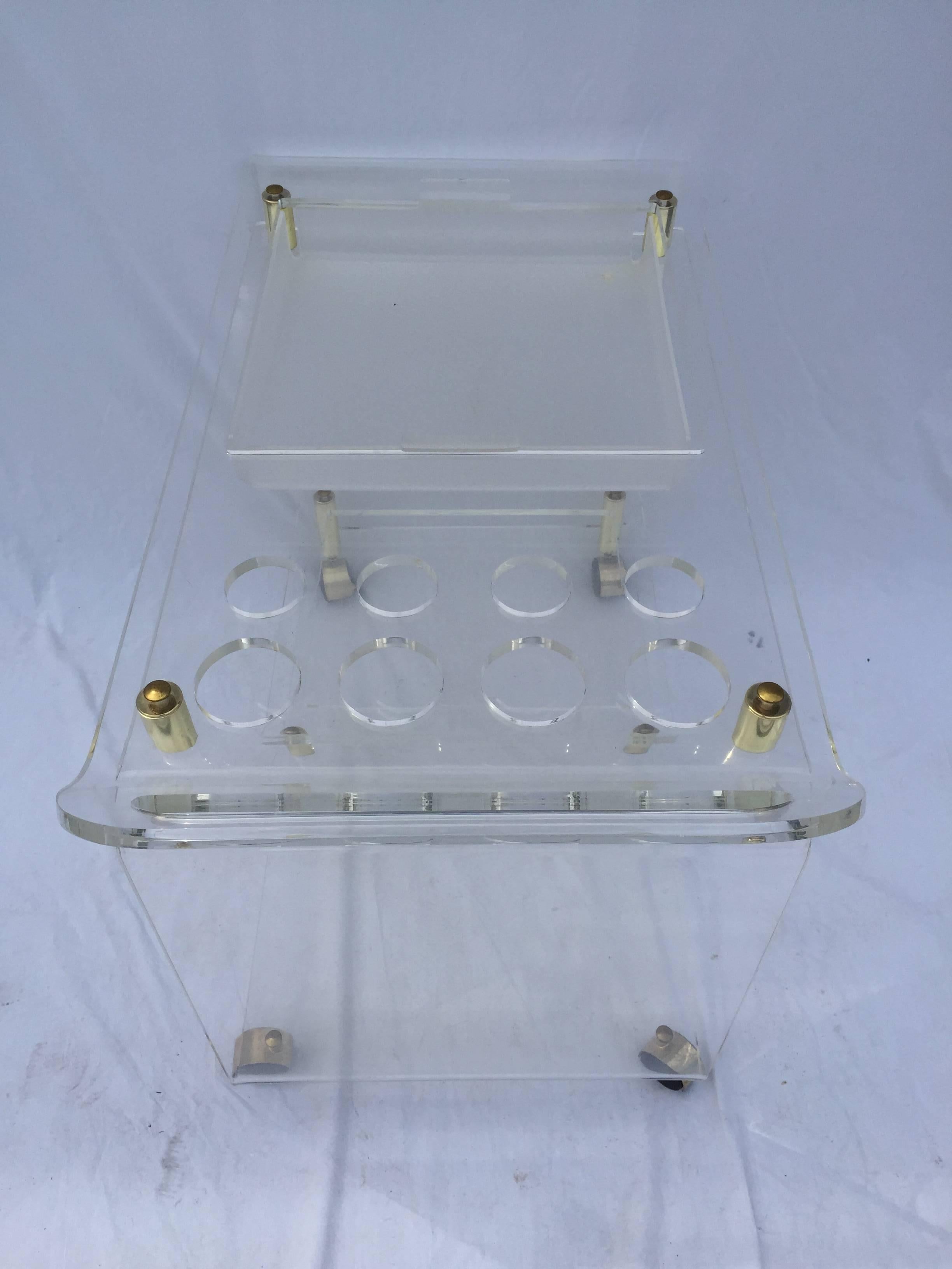 With ample room for glasses and bottles, a removable tray, brass accents and smooth rolling wheels - this vintage Lucite bar cart will make every cocktail that much more fun! Because, it's 5 o'clock somewhere! Cheers!