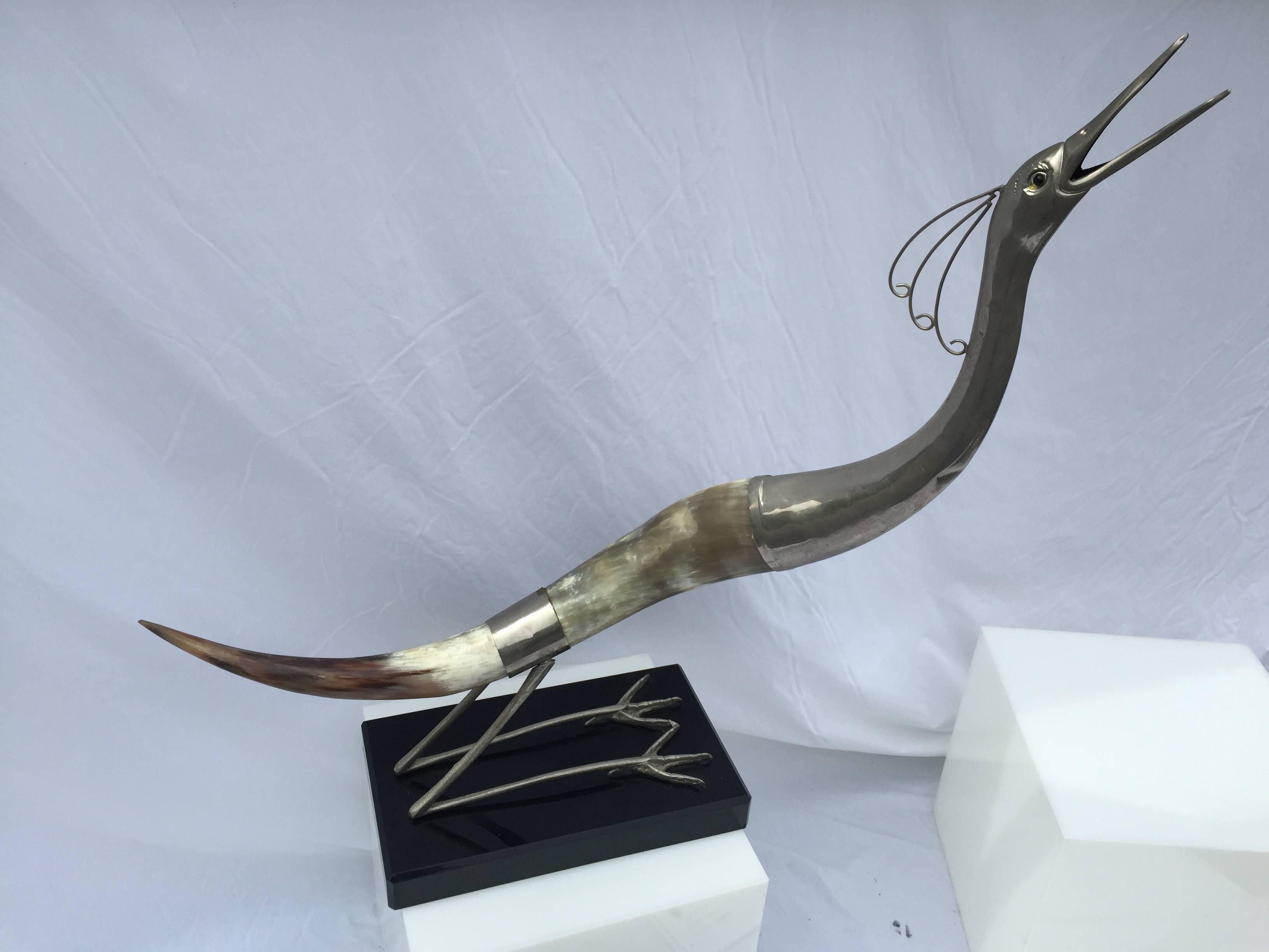 A pair of sculptural horn and silvered brass stylized birds. The approximate measurements are: 1). 38 inches high by 26 inches wide by 3.5 inches deep and 2). 37 inches high by 34 inches wide by 3.5 inches deep. Each base measures 9.75 inches deep