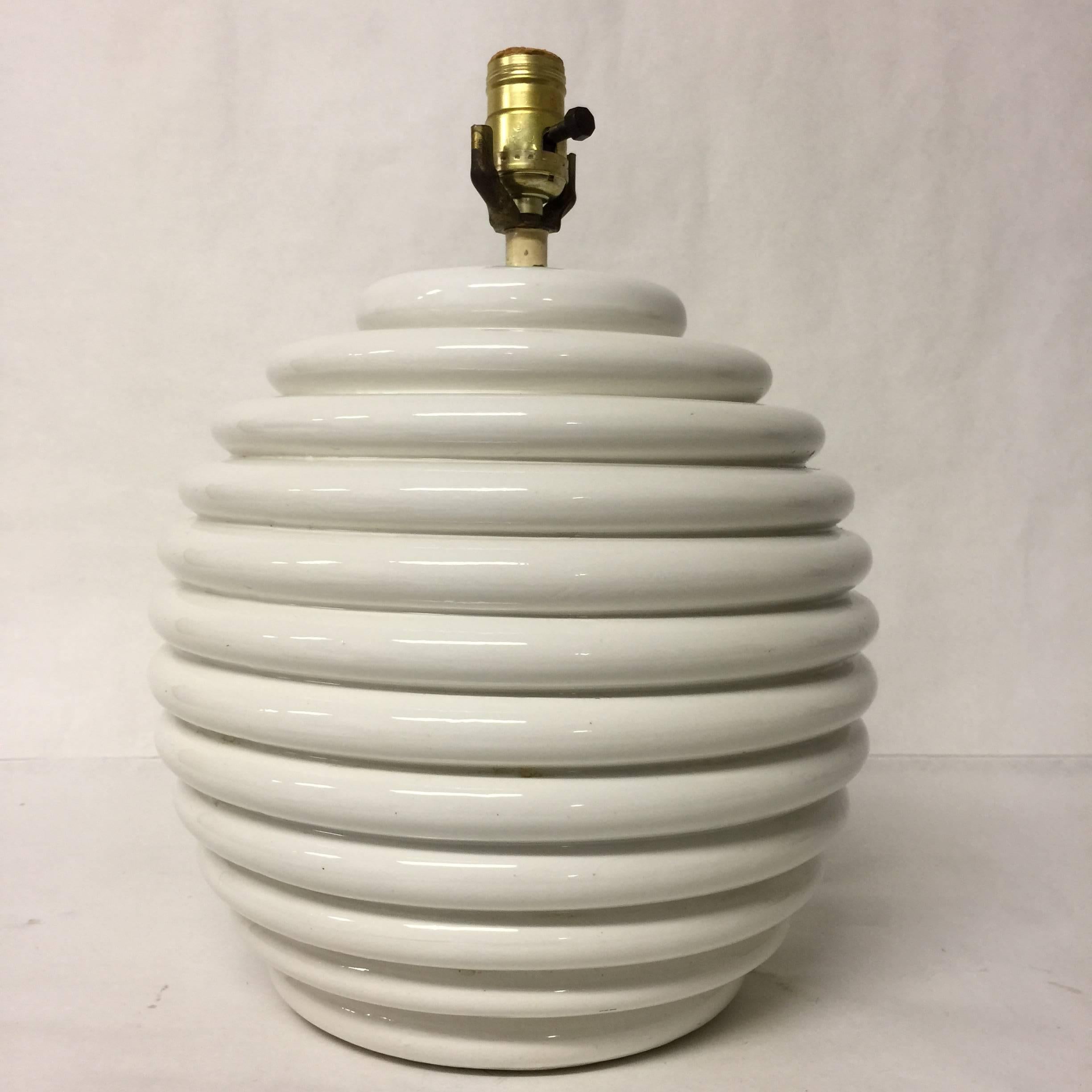 This vintage Italian table lamp has a 'base made in italy' label on the top and is signed on the bottom under the felt. It has a white, ribbed design on a rounded form. The lamp measures 15