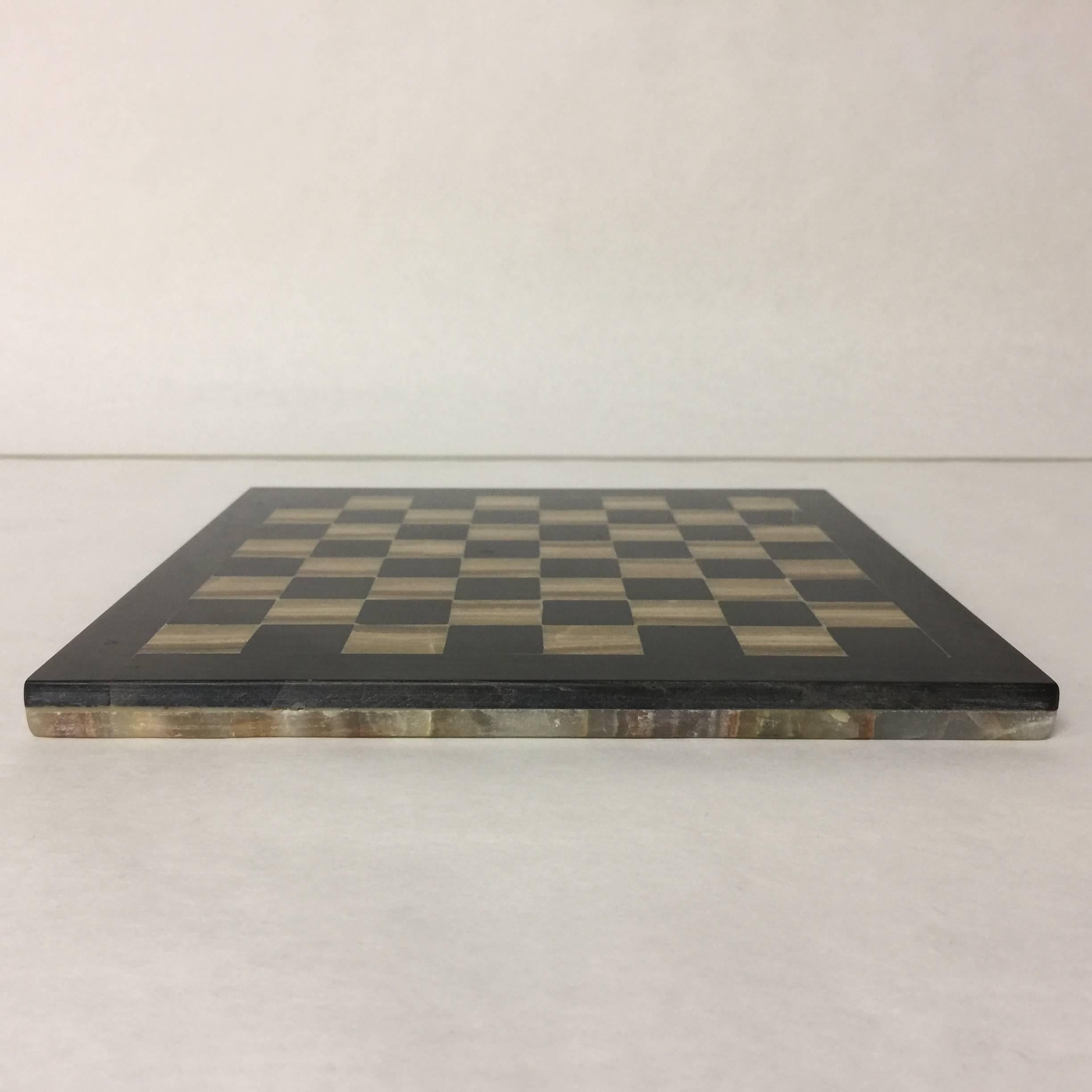 A perfect desk or coffee table accessory, this vintage agate chess or checkers board features two gorgeous sides. The game board side is done in shades of black and gold, while the other side is a patchwork design of agate.
