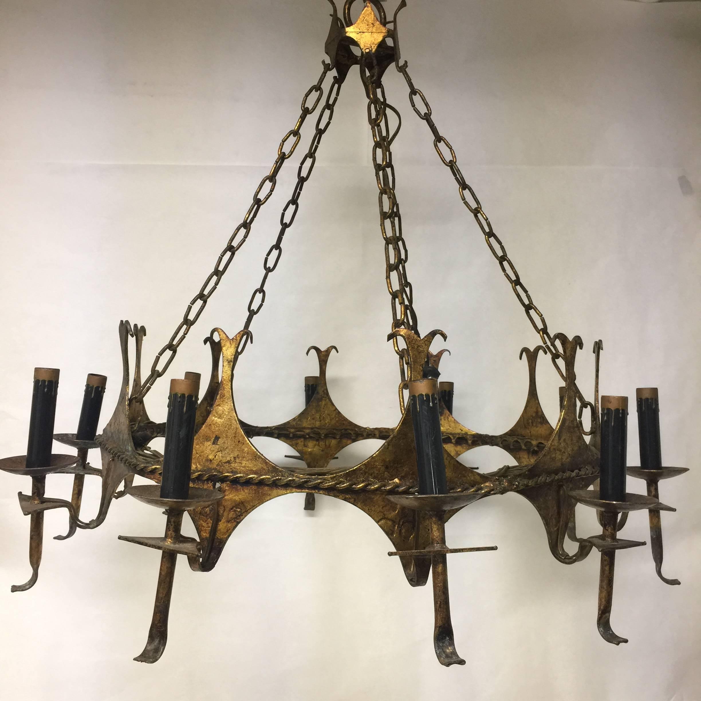 A vintage Mid-Century Spanish style gilt metal ten-light chandeliers with decorative candle covers. This chandelier has the five original gilt metal chains leading to the ceiling cap. There is a rope detail encircling the entire chandelier. Each