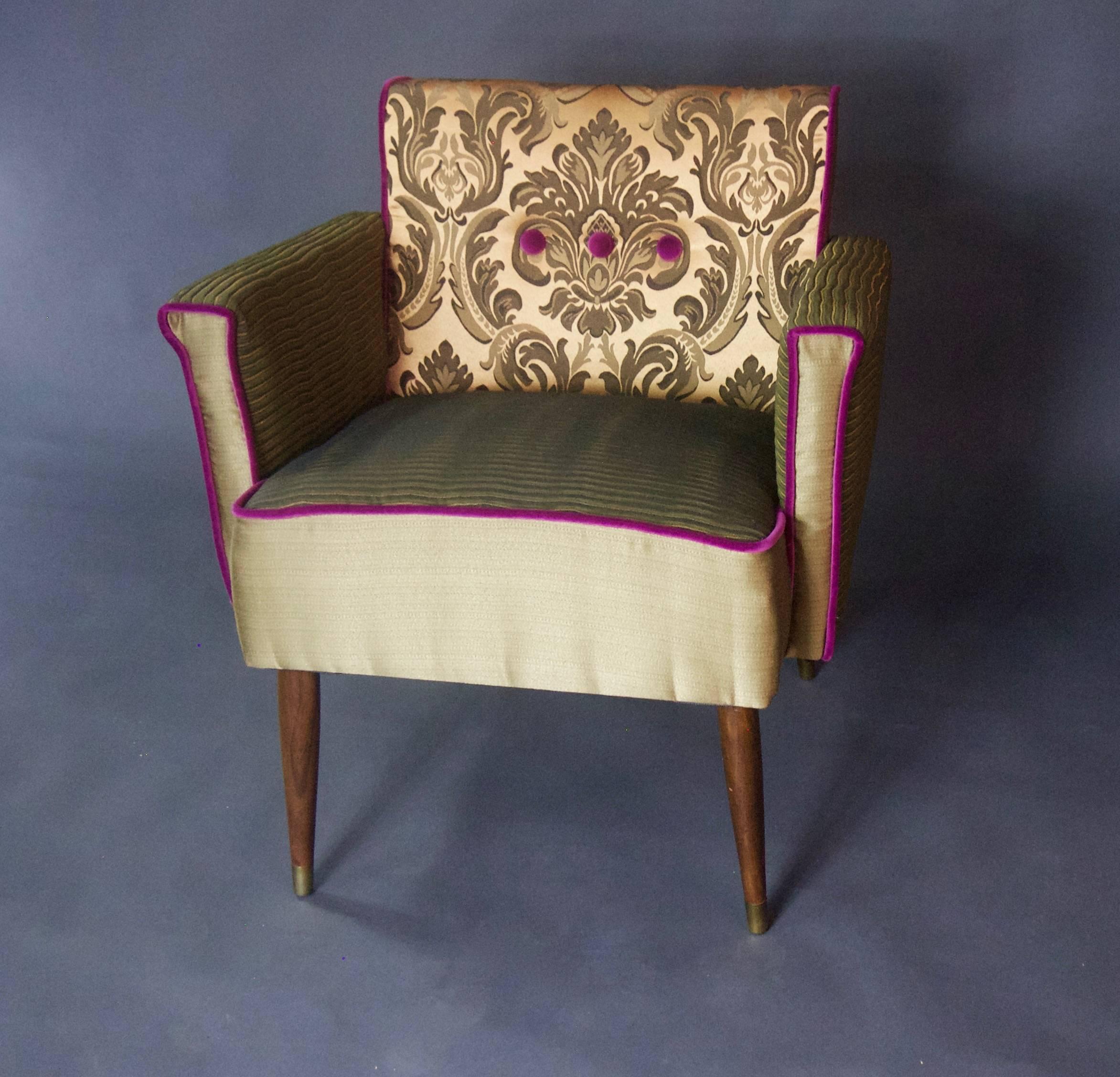 A low-slung armchair that looks straight off the set of Mad Men. It boasts a silk damask inside/outside back, with ribbed green seat and armrests and gold vertical panels--accented in a magenta velvet. 

An identical second chair is available so