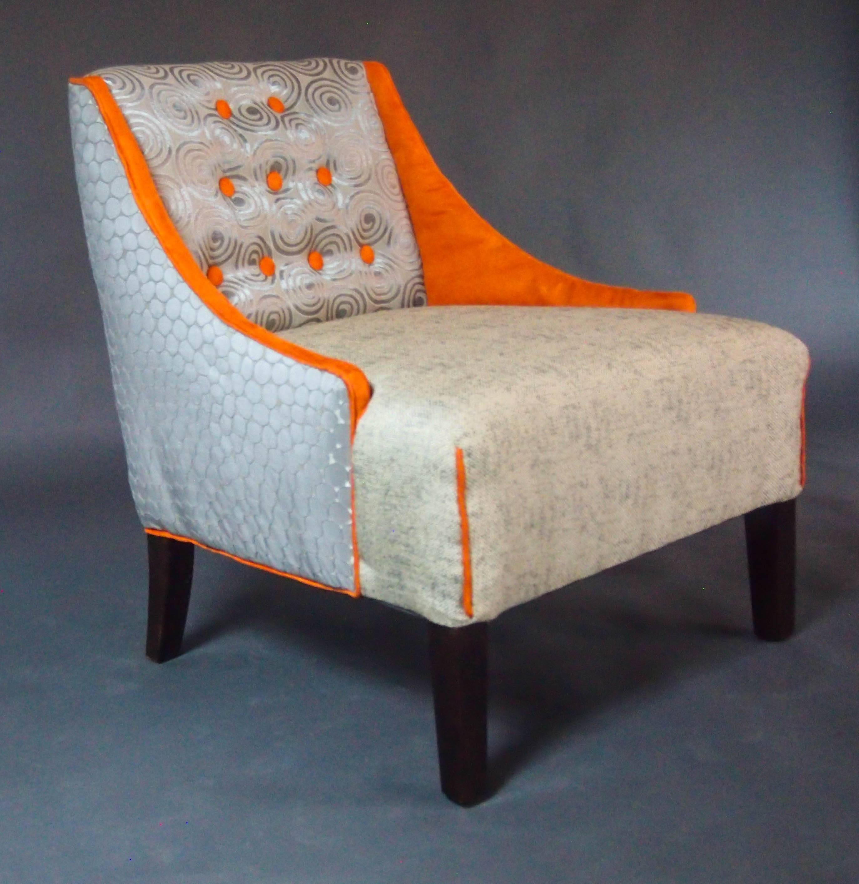 The Hollywood Regency style brought color and glamour to interior design. Now it can do the same for your living room. Sit back on luminous gray swirls, bright orange ultra suede armrests and a plush seat.

Like all of our pieces, this chair was