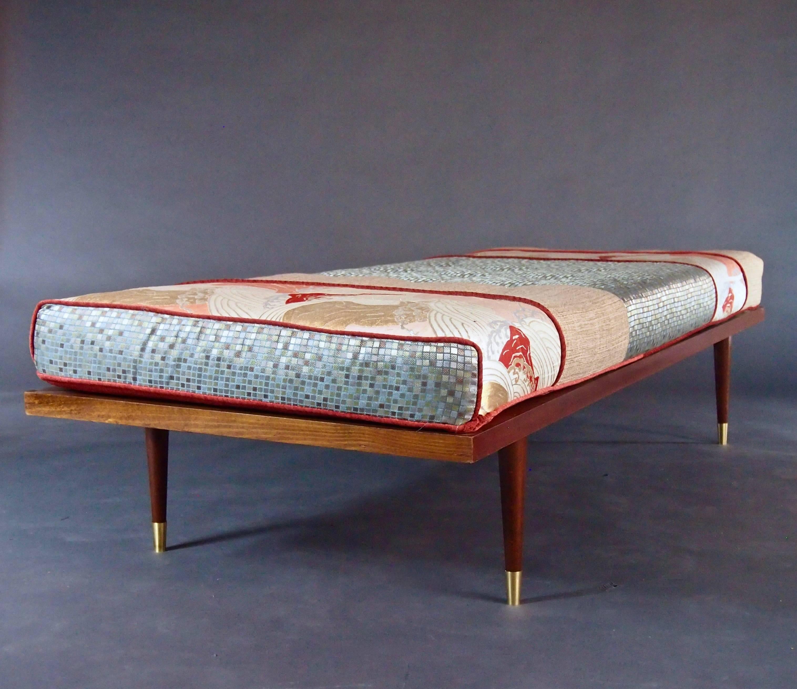 Spanning east and west, this Mid-Century daybed is a beautiful piece of artistry. It uses an authentic, vintage obi (the waist tie from a kimono) to tell the story of a volcano in gorgeous gold, silver, maroon and cantaloupe handwoven silk. Accented
