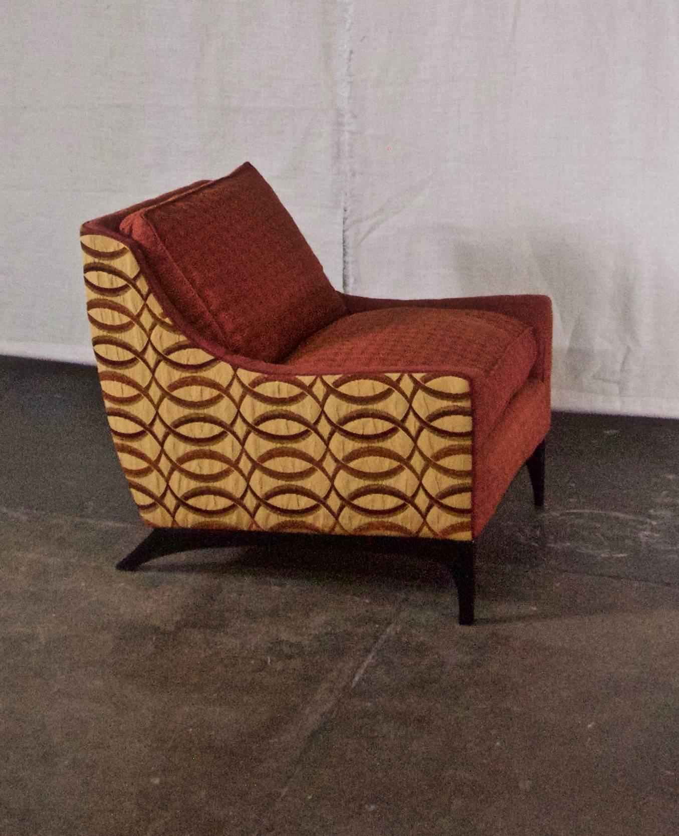 This midcentury lounge chair has super comfortable down/feather cushions and a style that suggests fluidity and motion. Woven fabrics are a combination of gold and deep red, as seen in photos. Base and legs are wood, stained black.

Vintage frame,
