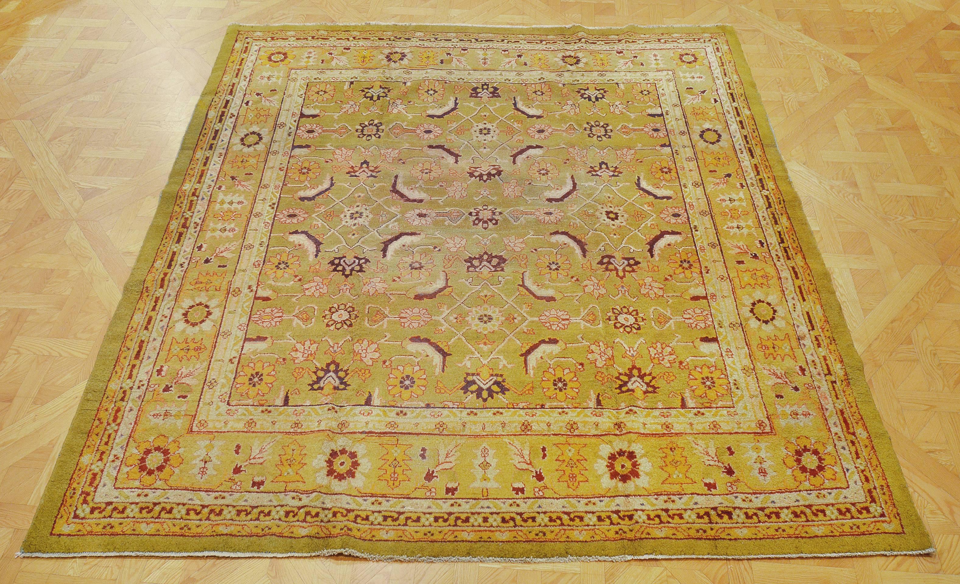 Questo tappeto tradizionale indiano Agra, tessuto a mano, presenta un campo morbido color chartreuse con un motivo herati angolato, con un bordo floreale a spirale color verde mela, tra una profusione di strisce di vite tonali e una striscia