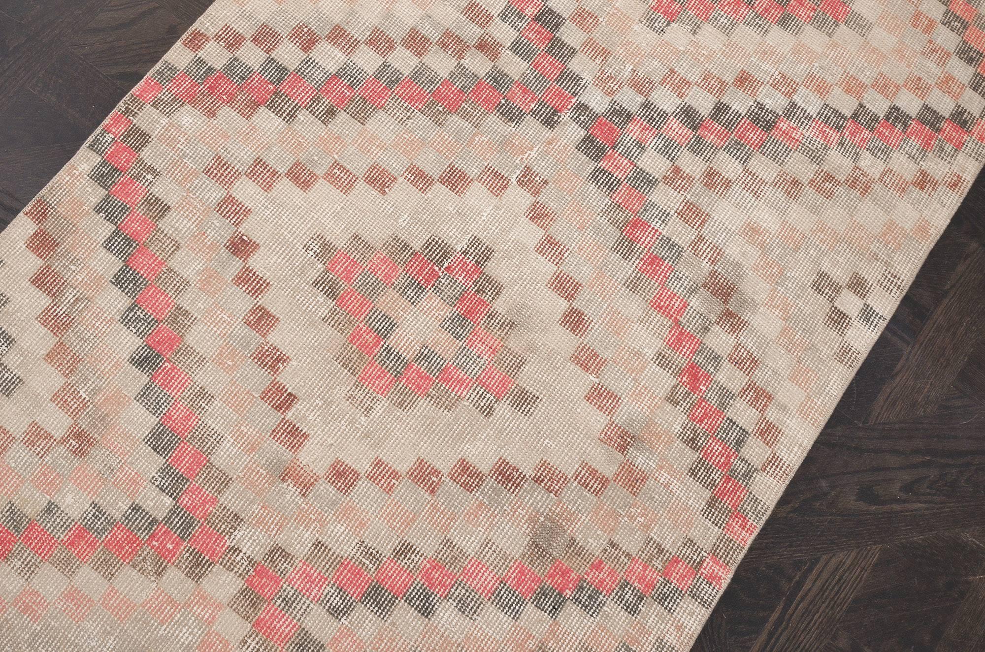 This handwoven Turkish deco rug has a lively beige field with central column of polychrome celled stepped lozenge medallions, with similar vibrant motif at each end. In order to soften the colors of this rug it has been antique washed. Originally
