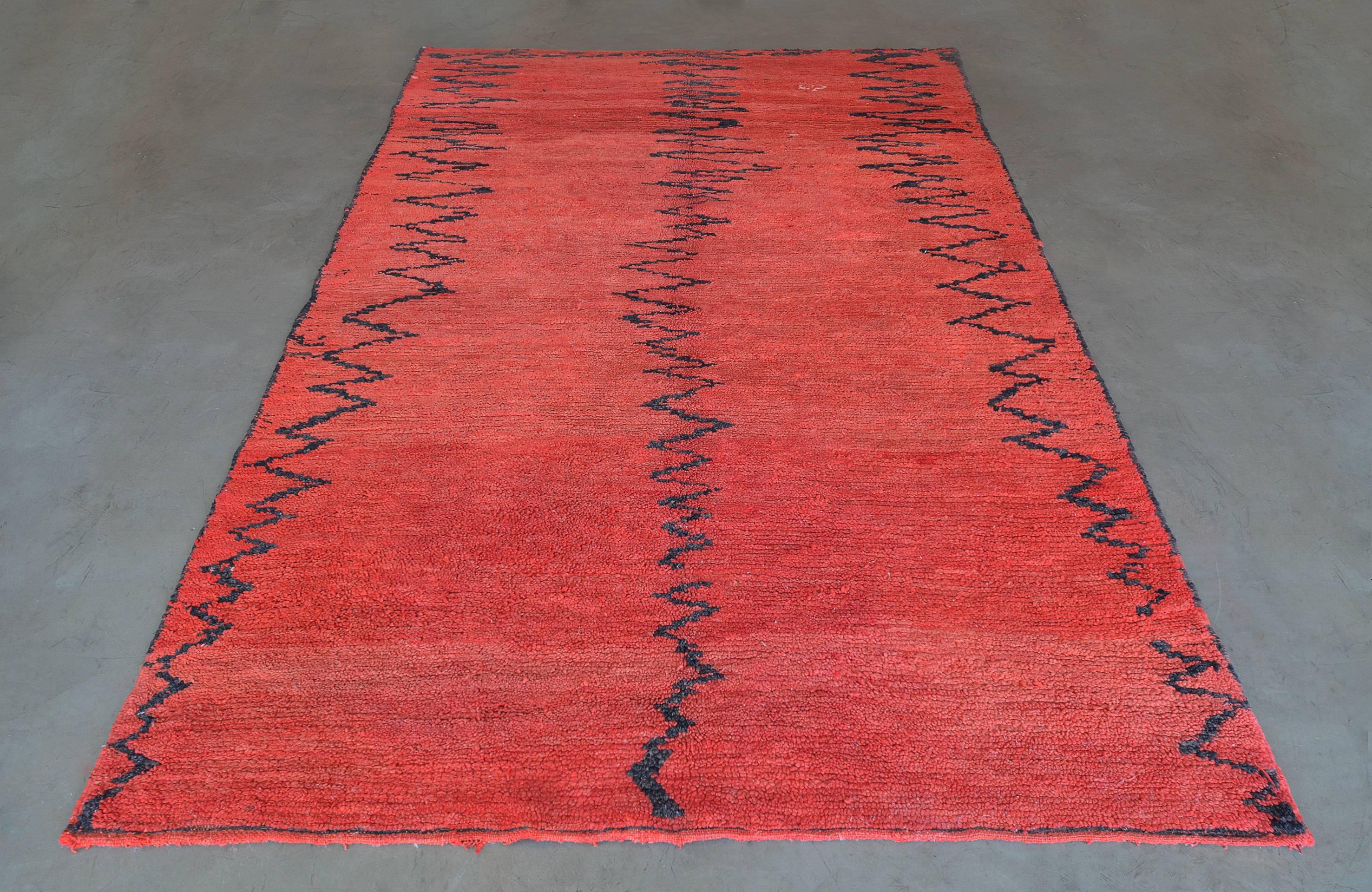 The coral-red field with three columns of zig-zag ribbon motifs.
